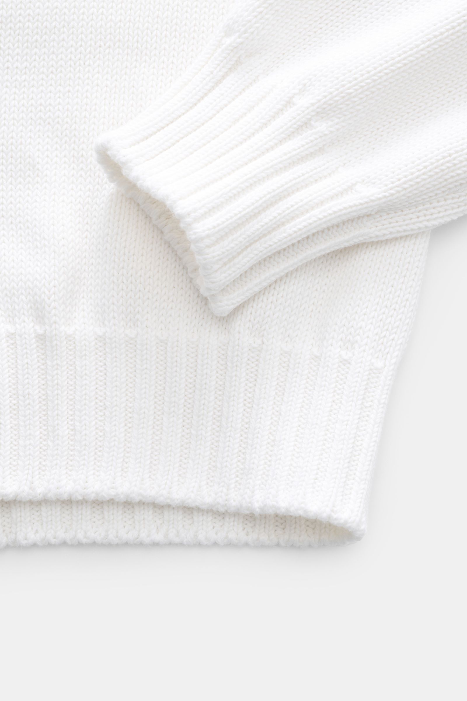 Close-up top-down view of the sleeve and hem of the Della Ciana Crew neck jumper white, showcasing its medium-fine pure Pima cotton knit and ribbed bands.

This elegant Italian cotton jumper by DELLA CIANA will enhance your spring wardrobe with its cla