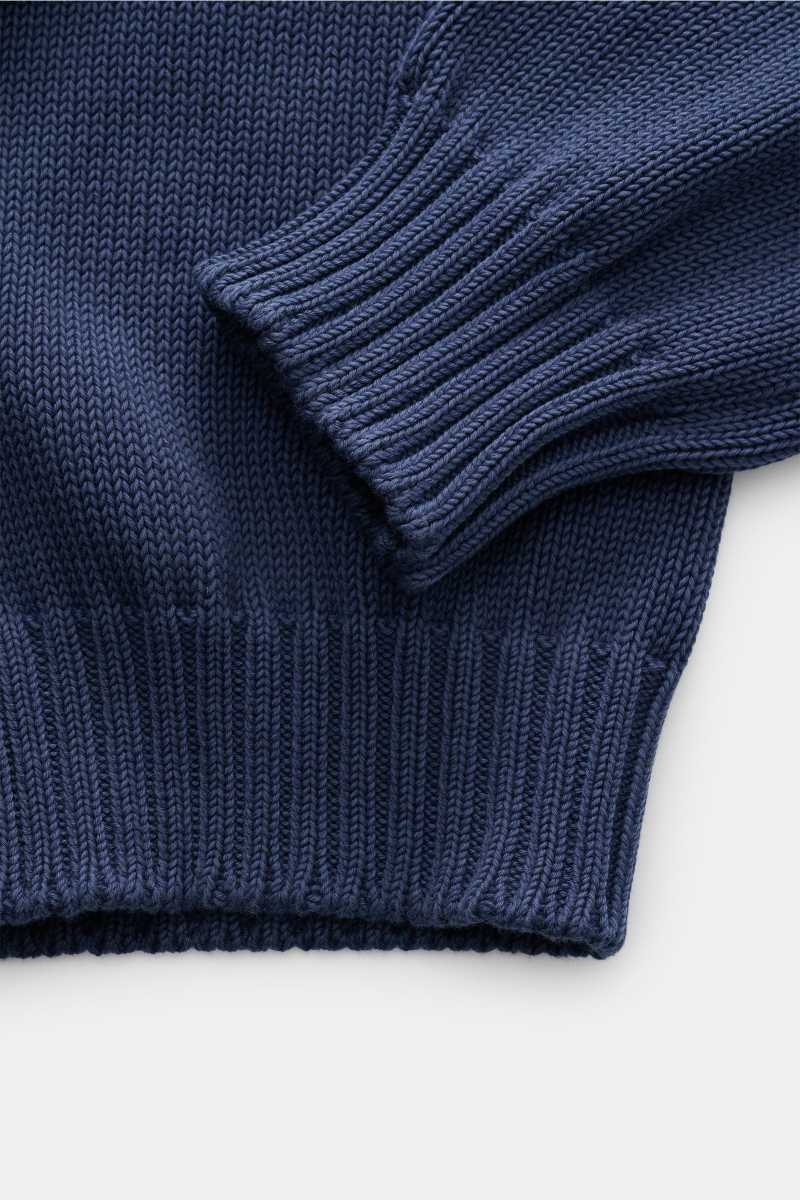 Close-up top-down view of the ribbed cuff and hem of the Della Ciana Crew neck jumper dark blue, showing fine knit texture.

This elegant Italian cotton jumper by DELLA CIANA will enhance your spring wardrobe with its classic fit and can be styled in a