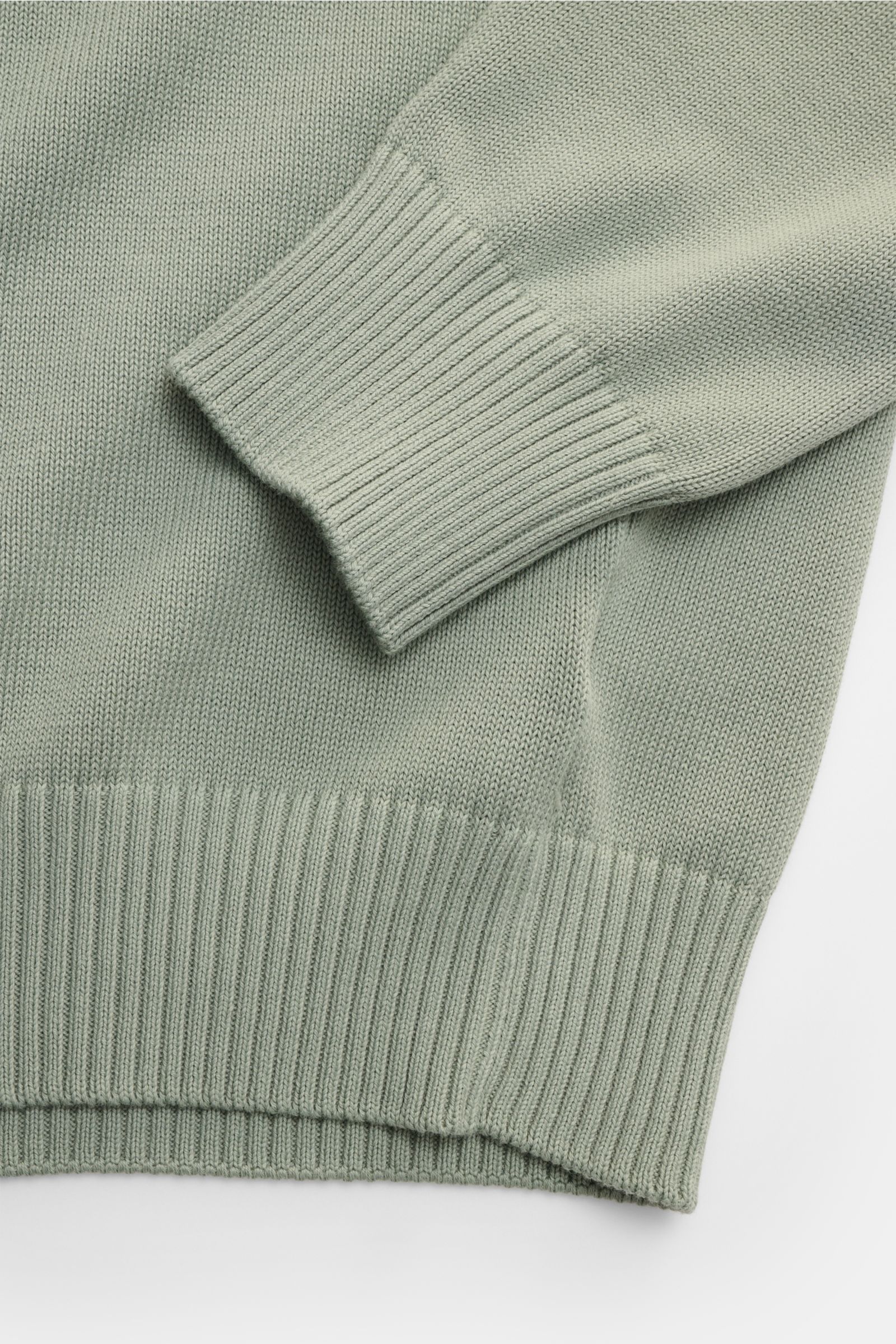 Gran Sasso Rundhalspullover salbei aus reiner Baumwolle, weicher Griff, feines Strickbild, Slim Fit mit Rundhals, Rippbündchen, Detailaufnahme von Ärmel und Saum.