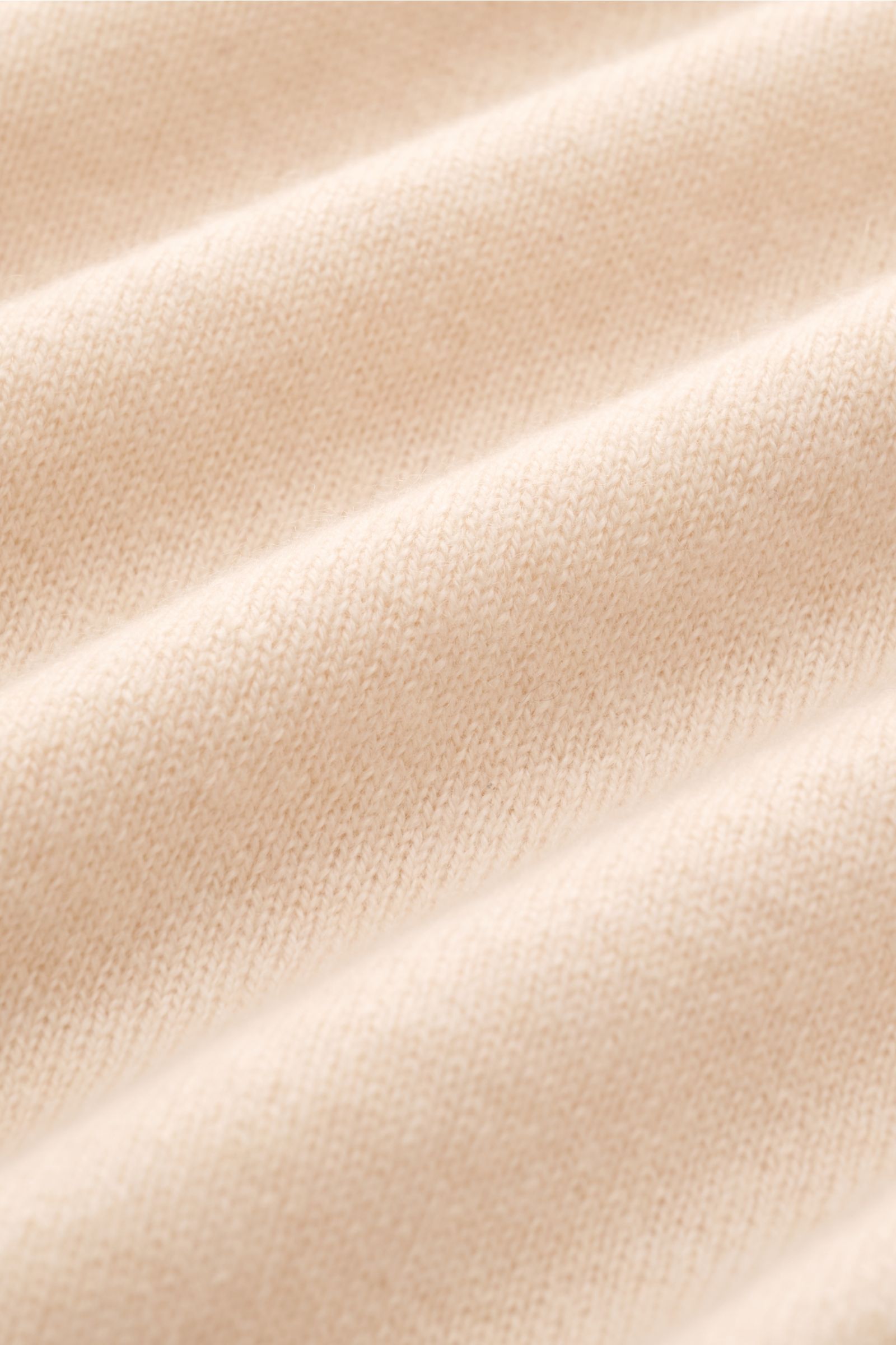Nahaufnahme des feinen Strickbilds und weichen Griffs des Bruno Manetti Cashmere Rundhalspullover sand aus reiner Cashmere-Qualität.