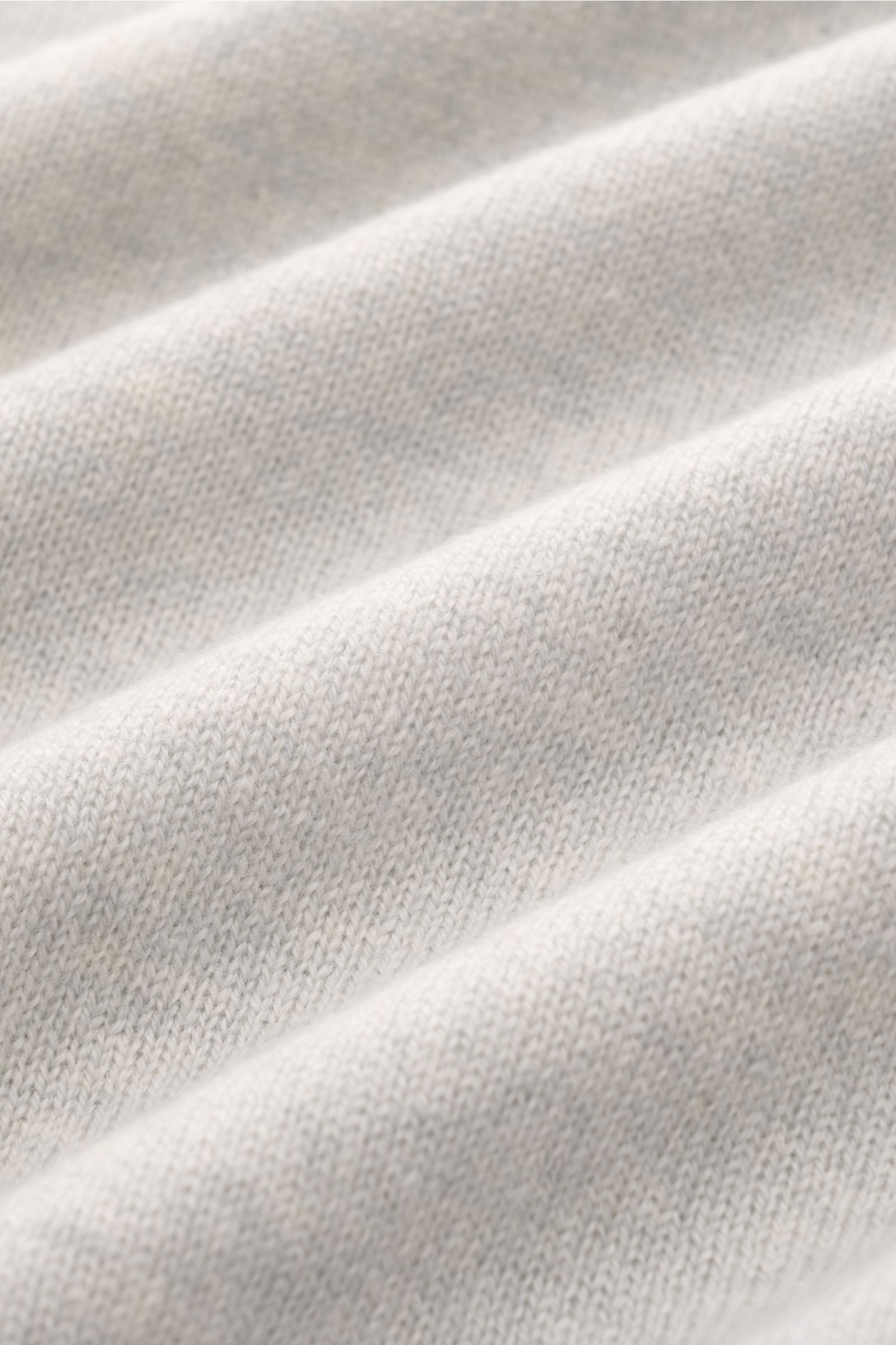 Nahaufnahme des feinen Strickbilds eines hellgrau melierten Bruno Manetti Cashmere Rundhalspullover mit weichem Griff und komfortablen Rippbündchen.