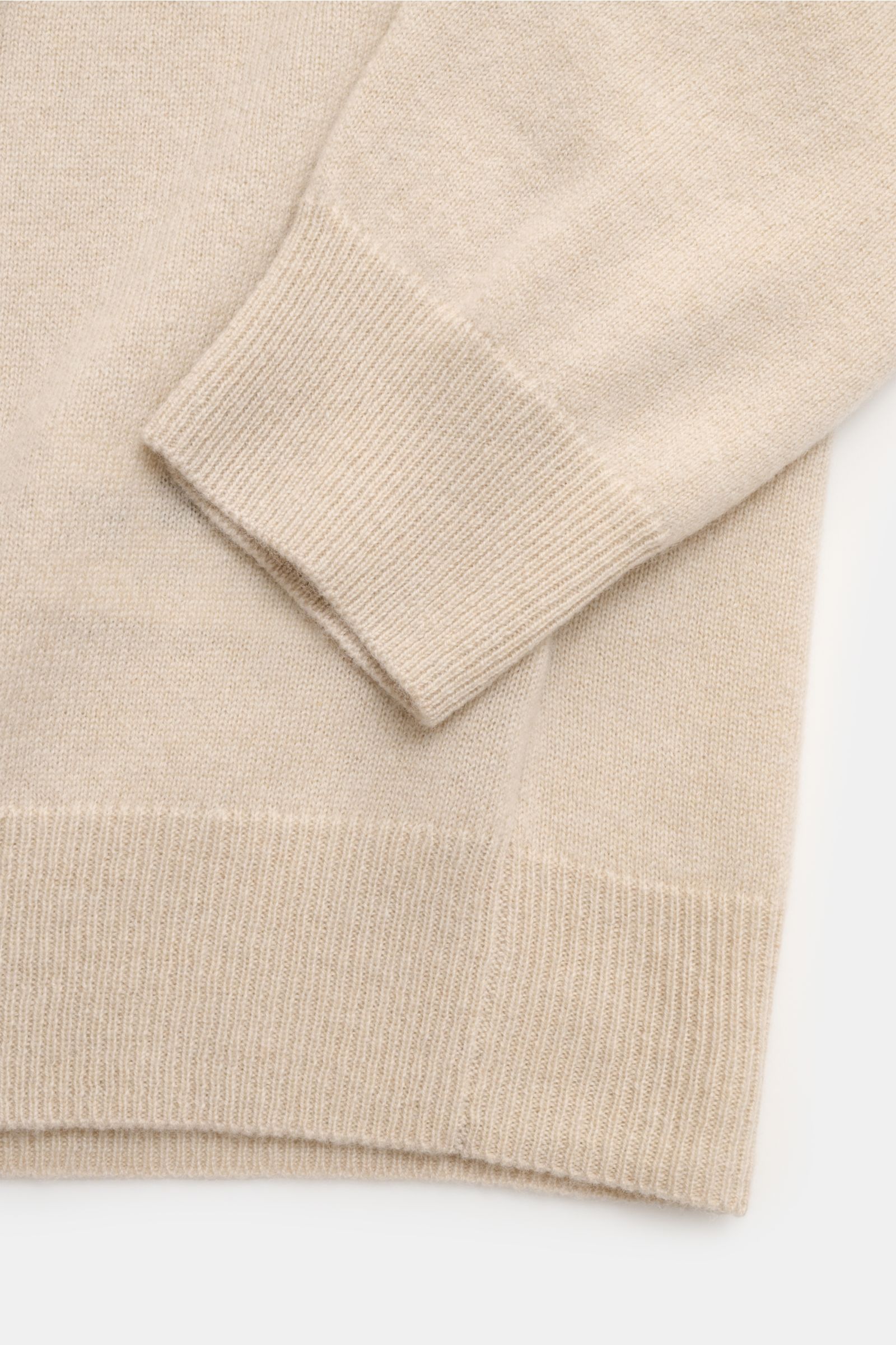 Nahaufnahme des FTC Cashmere Rundhalspullover beige von schräg oben, zeigt feines Strickbild, Slim Fit, Rundhalsausschnitt, ultraweiche Cashmere-Qualität und komfortable Rippbündchen.