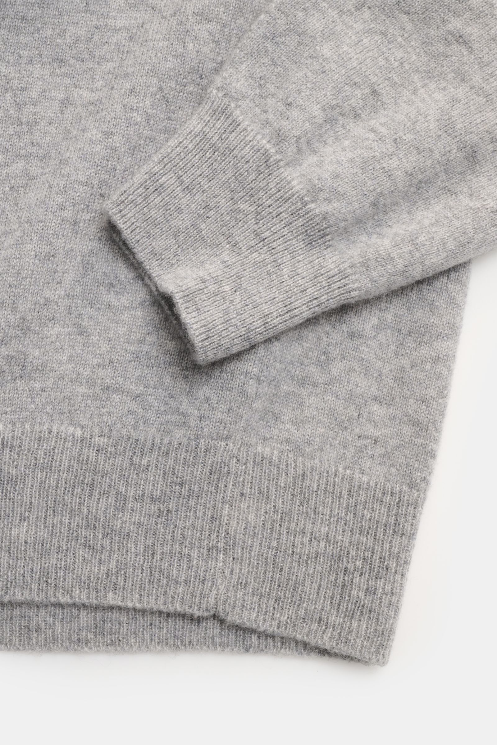 Close-up view of the FTC Cashmere Rundhalspullover grau meliert showing the fine knit, ribbed cuffs, and hem in soft grey cashmere.

Das Tragegefühl ultraweicher Cashmere-Qualität lässt diesen zeitlosen Rundhalspullover vom nachhaltigen Stricklabel FTC