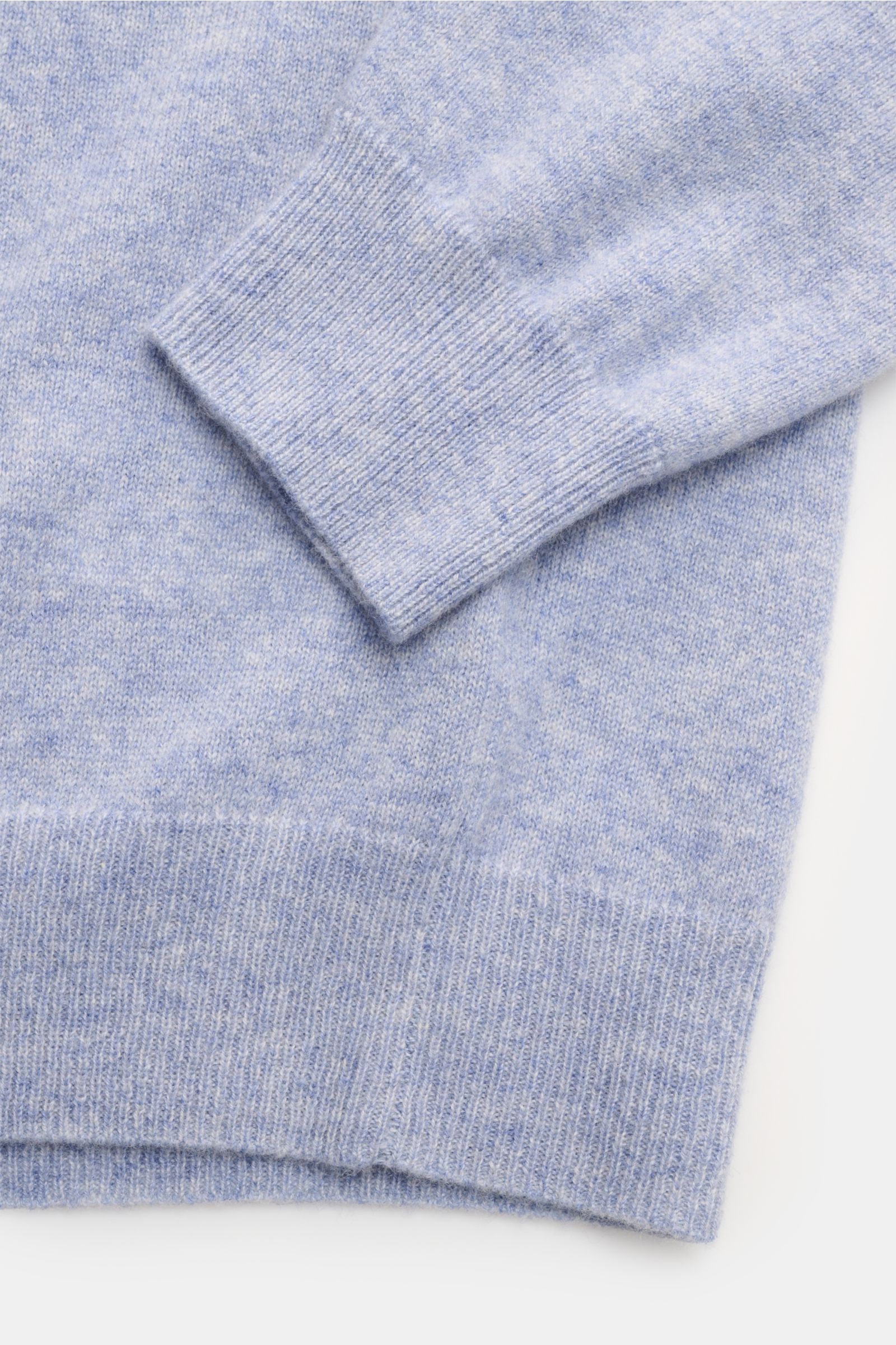 Close-up view of the FTC Cashmere Rundhalspullover hellblau meliert showing the fine knit, ribbed hem, and cuff details in light blue melange.

Das Tragegefühl ultraweicher Cashmere-Qualität lässt diesen zeitlosen Rundhalspullover vom nachhaltigen Stri