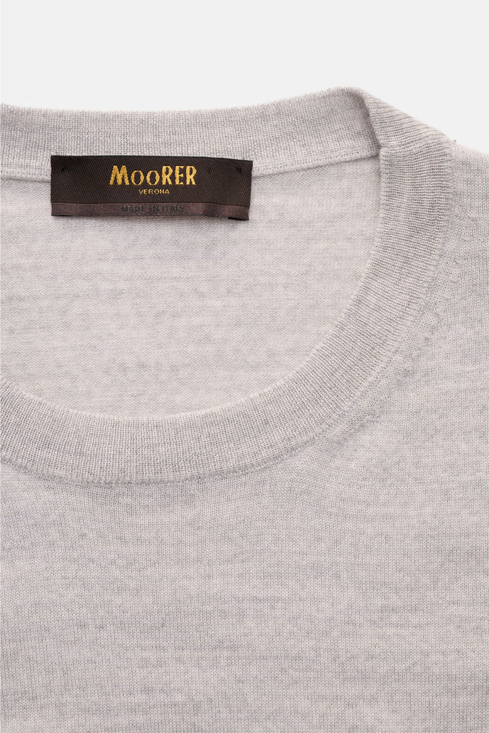 Close-up front view of the gray melange Moorer Rundhalspullover 'Orvieto' with round neckline and fine wool knit.  
Puristische Raffinesse: In feinem Schurwollstrick gefertigt, verbindet der Rundhalspullover von MOORER höchste Handwerkskunst mit klassi
