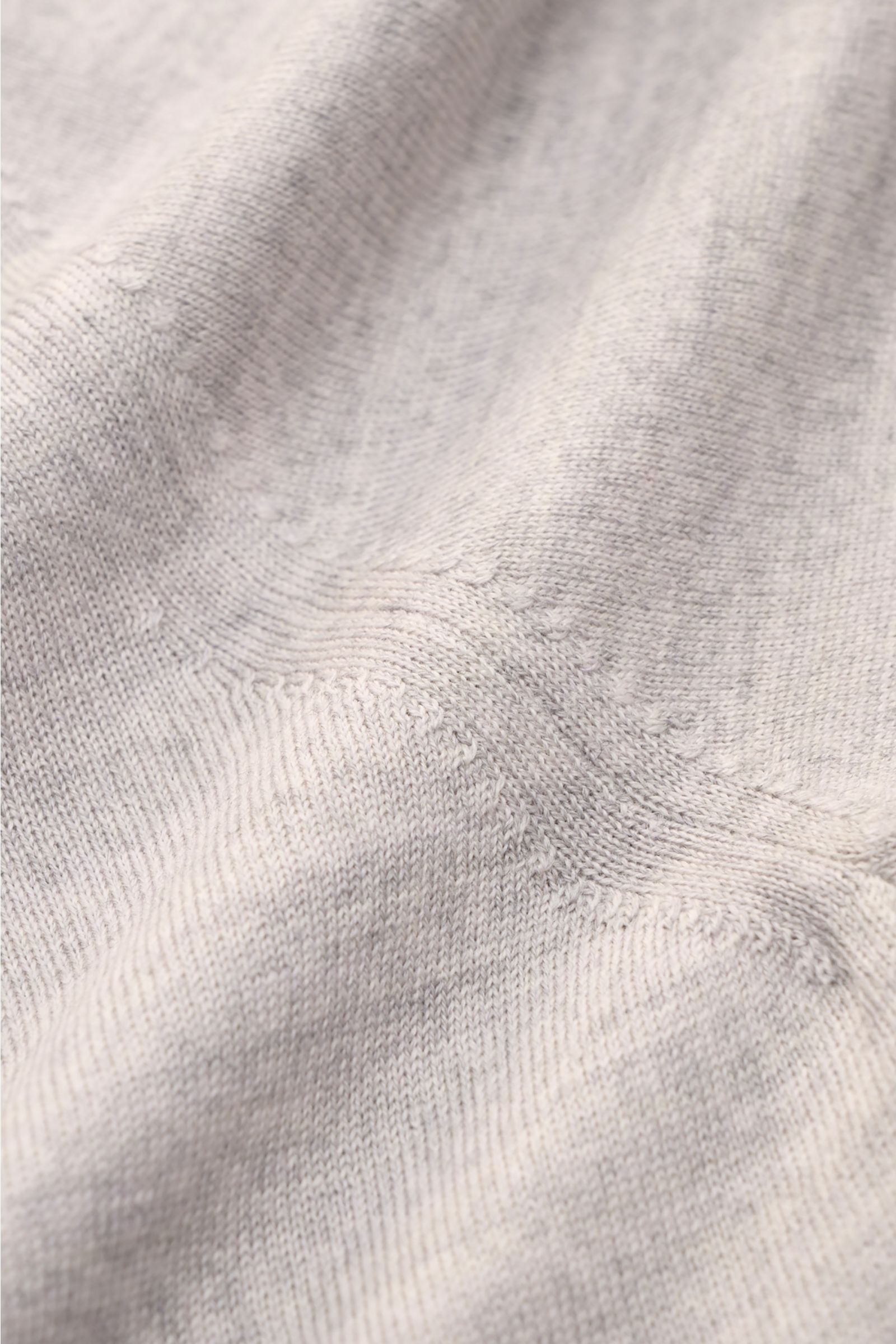 Close-up of the fine knit texture of the Moorer Rundhalspullover 'Orvieto' grau meliert, showing soft pure wool fabric.

Puristische Raffinesse: In feinem Schurwollstrick gefertigt, verbindet der Rundhalspullover von MOORER höchste Handwerkskunst mit k