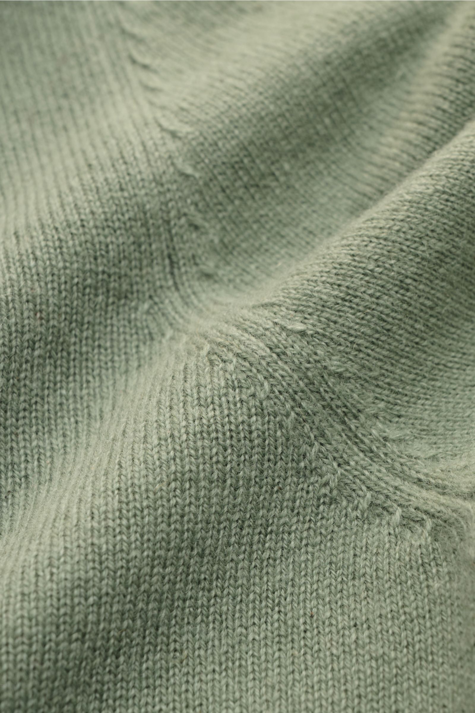 Nahaufnahme des feinen Strickbilds vom von Braun Cashmere Rundhalspullover salbei, weich, Slim Fit, mit Rundhalsausschnitt und flexiblen Rippbündchen.