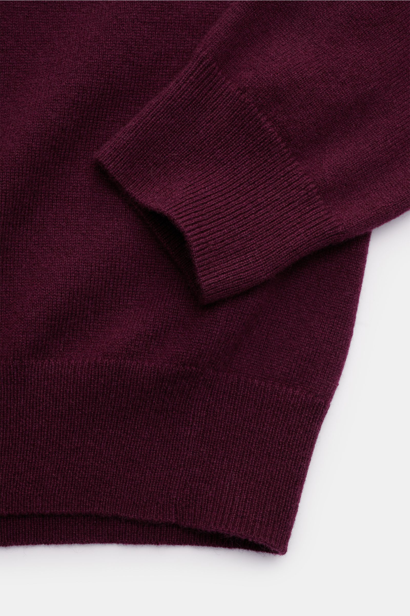 Nahaufnahme des von Braun Cashmere Rundhalspullover bordeaux, Slim Fit mit feinem Strickbild, Rundhalsausschnitt und flexiblen Rippbündchen, aus weichem, reinem mongolischem Cashmere, fotografiert von oben.