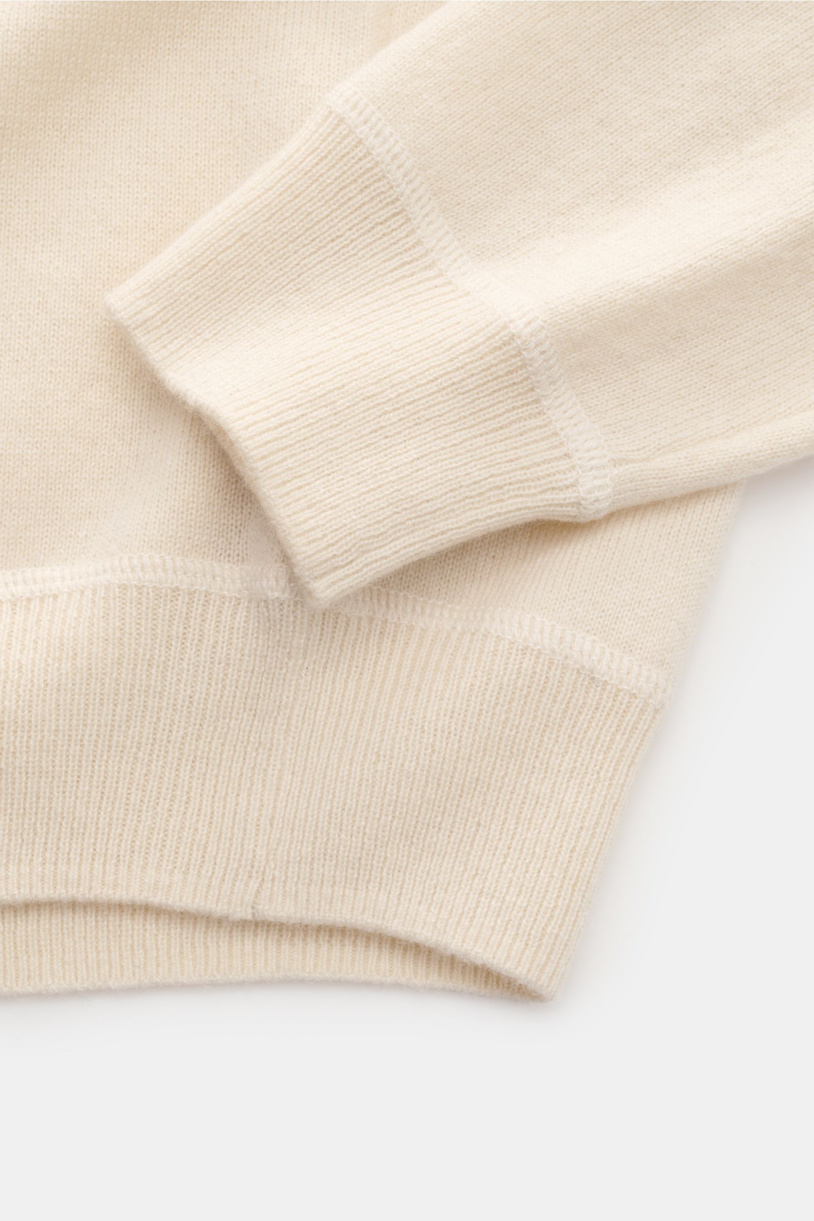 Nahaufnahme des von Braun Cashmere Rundhalspullover creme von oben, zeigt weiche Rippbündchen, Raglanärmel und feines Strickbild aus reinem Cashmere.