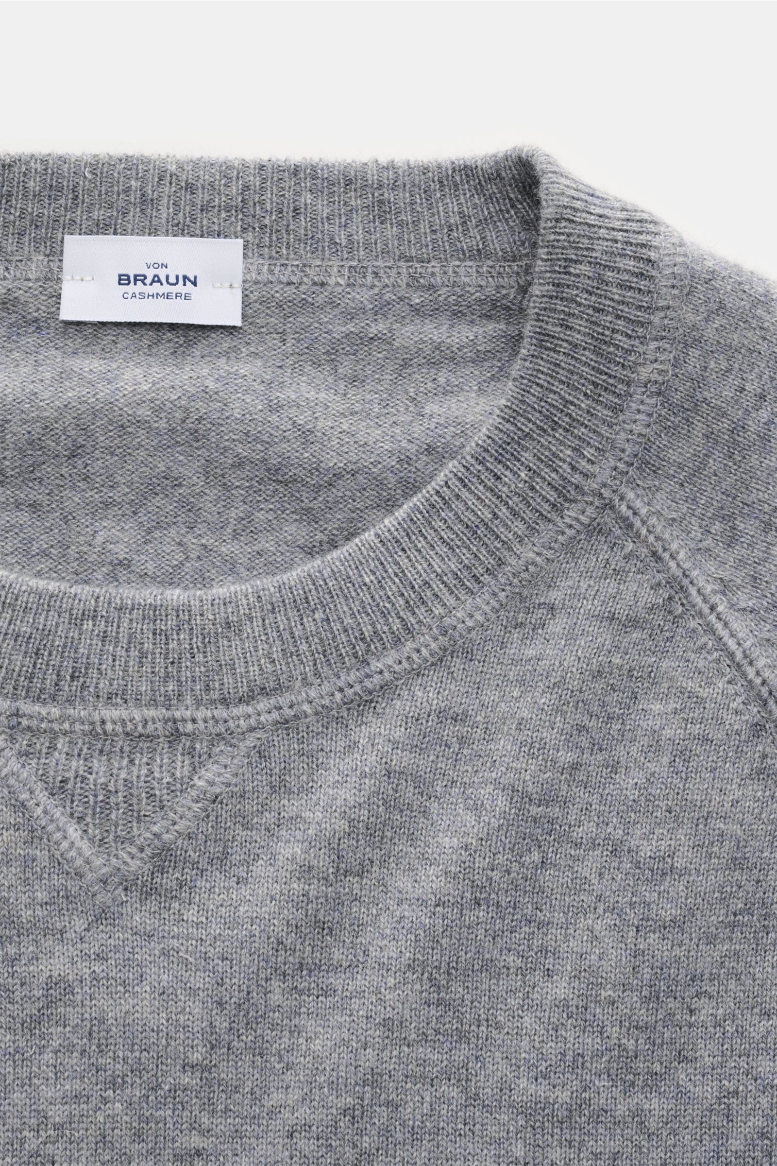 Nahaufnahme von oben auf den von Braun Cashmere Rundhalspullover grau meliert mit Rundhalsausschnitt, Raglanärmeln und feinem Strickbild.