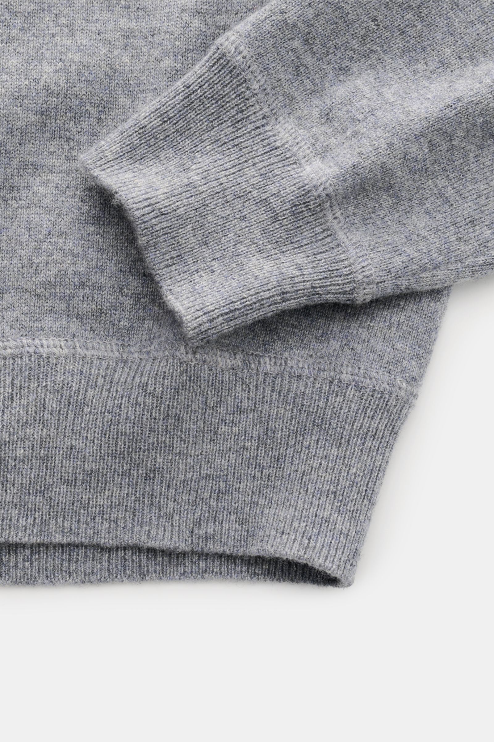 Nahaufnahme des von Braun Cashmere Rundhalspullover grau meliert von oben rechts, zeigt feines Strickbild, Raglanärmel und Rippbündchen.