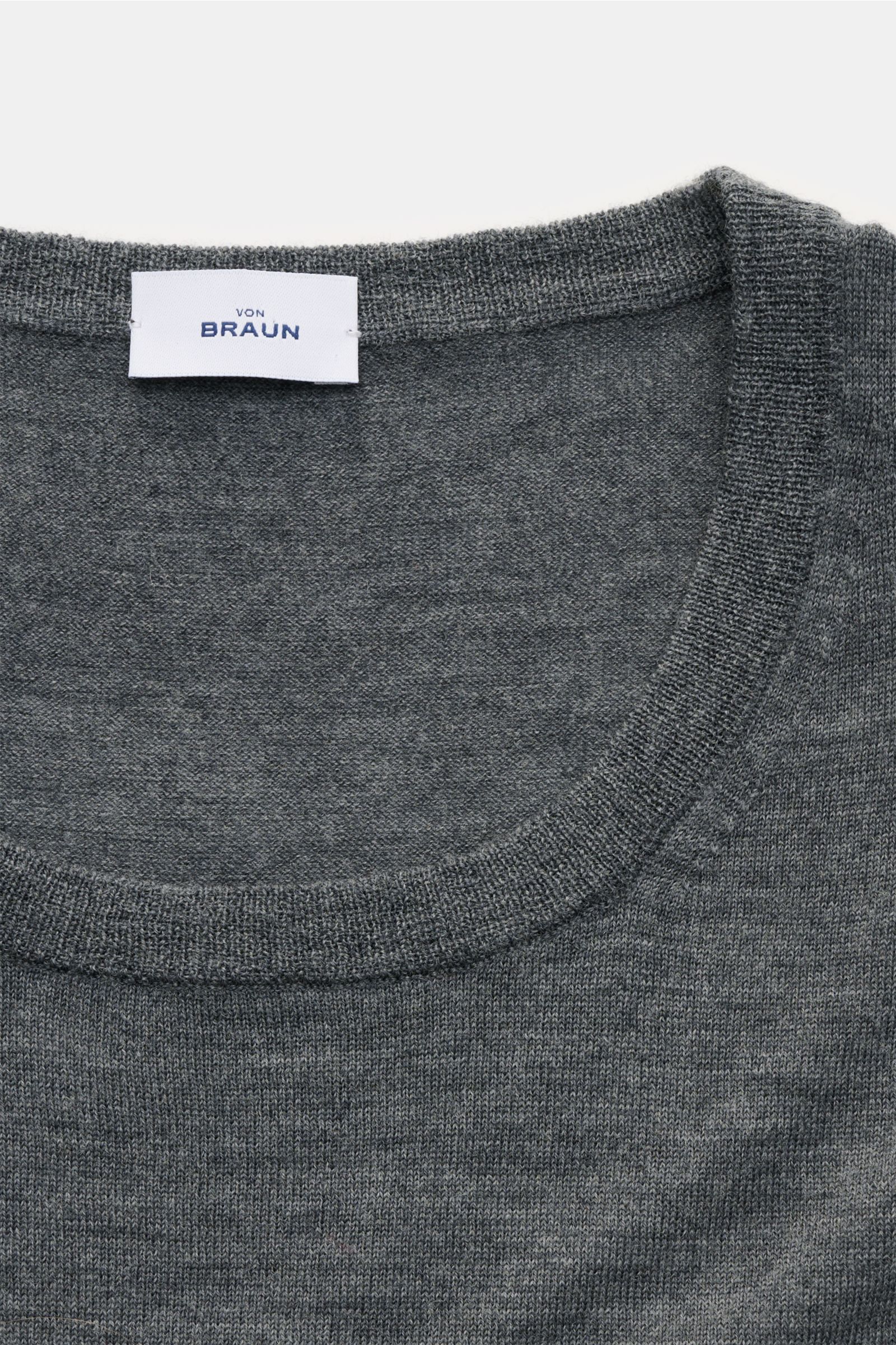 Nahaufnahme des von Braun Merino Rundhalspullovers grau meliert mit Rundhalsausschnitt, feinem Strickbild und weichem Griff.