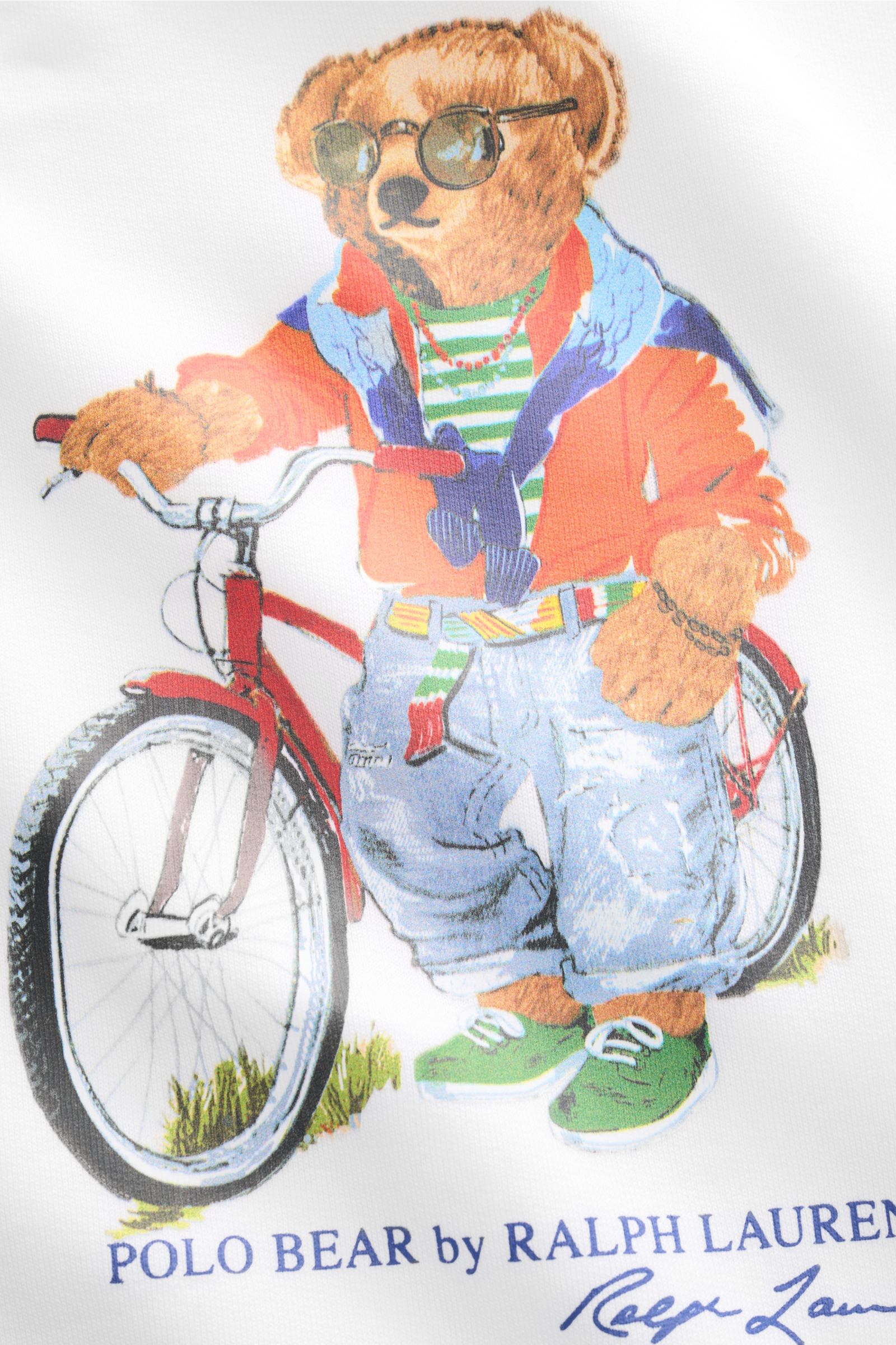 Close-up front view of Polo Ralph Lauren Sweatshirt white showing the Polo Bear print with sunglasses and bike, soft brushed inside.

The Polo Bear by POLO RALPH LAUREN is back and makes a fashion statement with a bike in casual look on this sweatshirt
