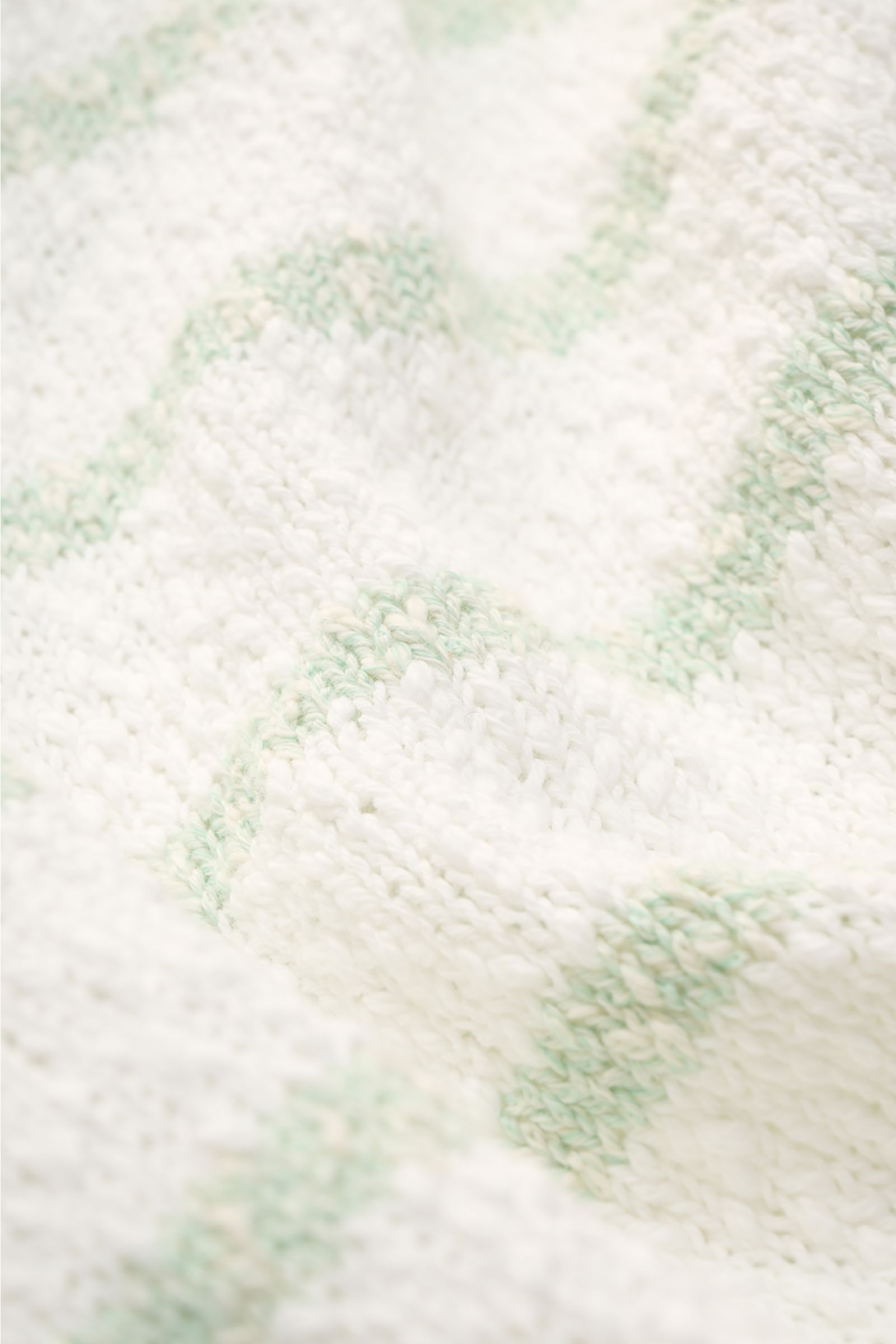 Nahaufnahme des 04651/ A trip in a bag Rundhalspullover 'Mouline Striped' offwhite/salbei gestreift mit grobem Strickbild und klassischem Streifenmuster aus leichter Baumwolle.