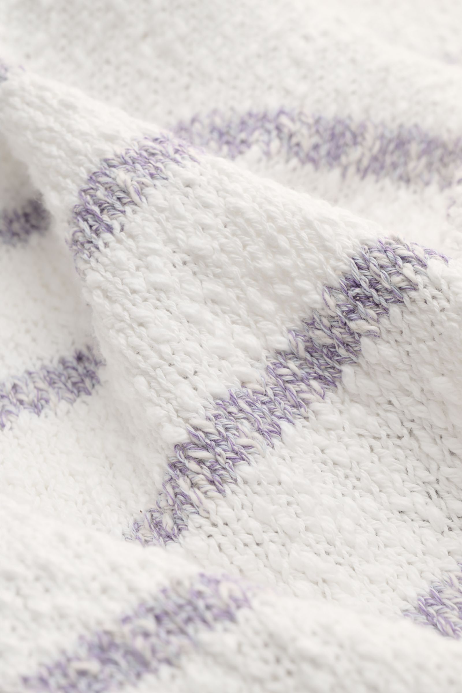 Makroaufnahme des grob gestrickten 04651/ A trip in a bag Rundhalspullover 'Mouline Striped' offwhite/lavender gestreift mit klassischem Streifenmuster aus reiner Baumwolle.
