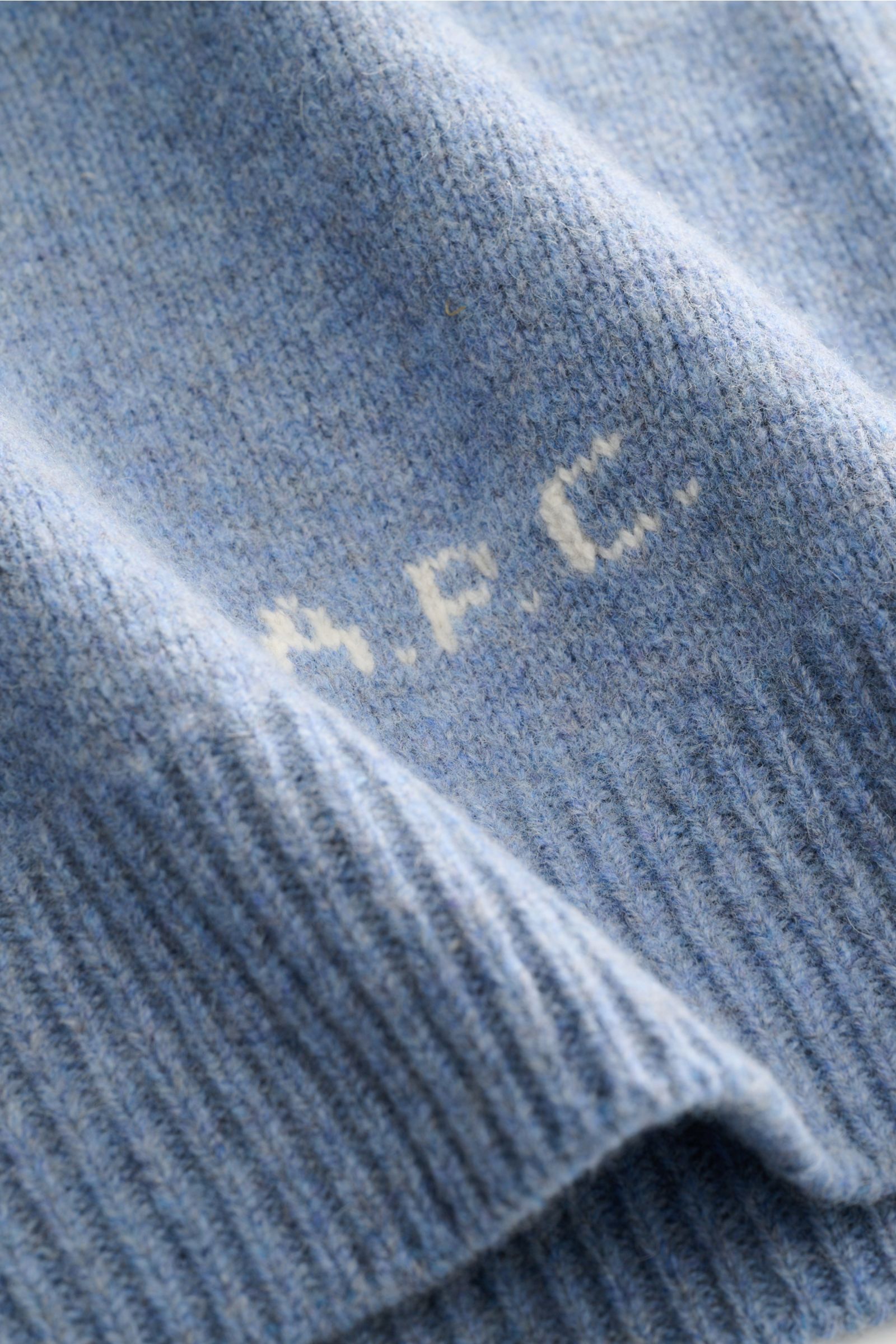 Nahaufnahme des A.P.C. Rundhalspullover 'Edmond' rauchblau meliert, Detail der reinen Wolle und kontrastfarbenem Logo am Bund.