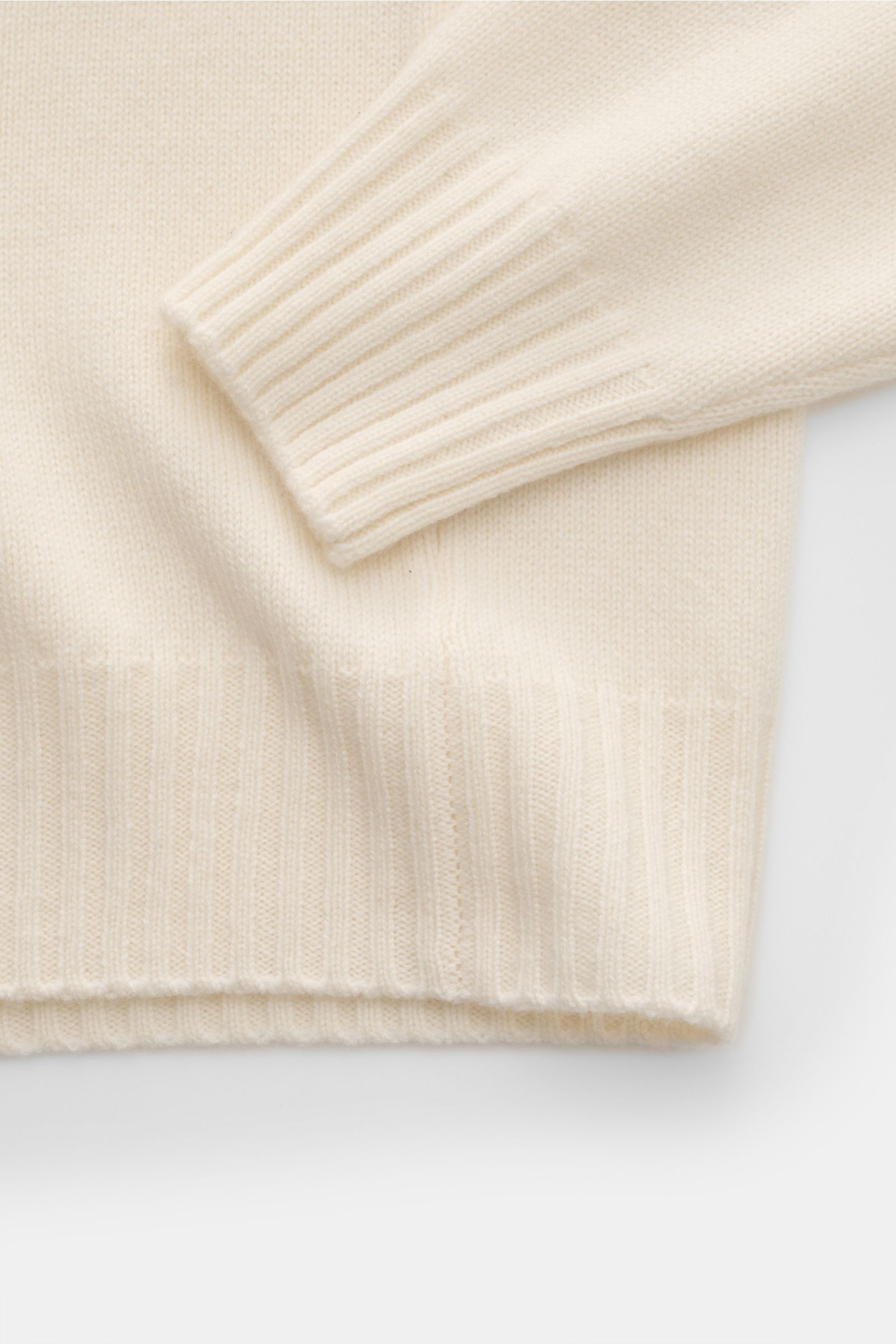 Close-up view of the sleeve and hem of the 04651/ A trip in a bag Cashmere Rundhalspullover creme, made from soft pure cashmere with ribbed cuffs and fine knit texture.

Description: Essenziell für kühle Tage: Der softe Pullover aus der 'Alpine' Capsul