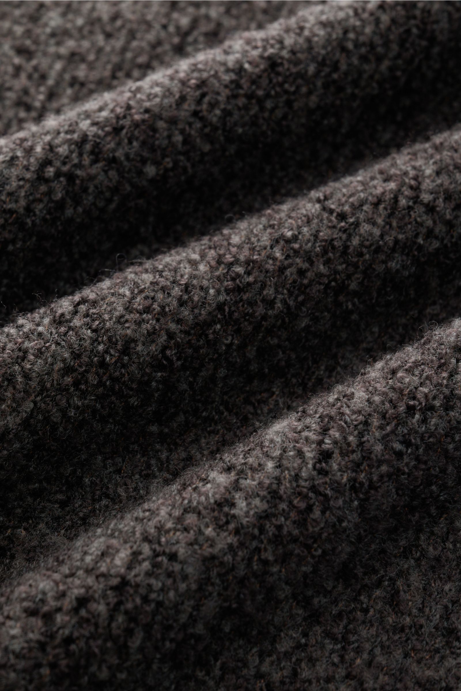 Nahaufnahme des graubraunen Boucléstricks vom 04651/ A trip in a bag Mock Neck Pullover 'Grainy' aus wärmendem Woll-Mix mit mittelfeinem Strickbild.