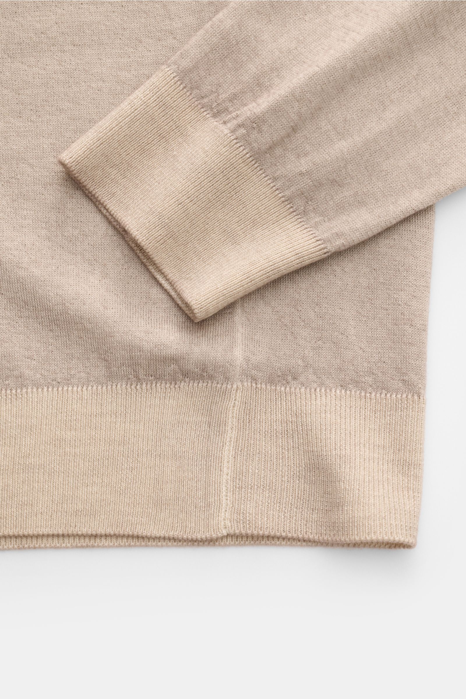Close-up top-down view of the sleeve and hem of the Malo Cashmere crew neck jumper beige mottled, showing fine knit and ribbed bands.

Description: A essential for cooler days: This cashmere jumper by MALO features fine fabric and is a stylish part of 