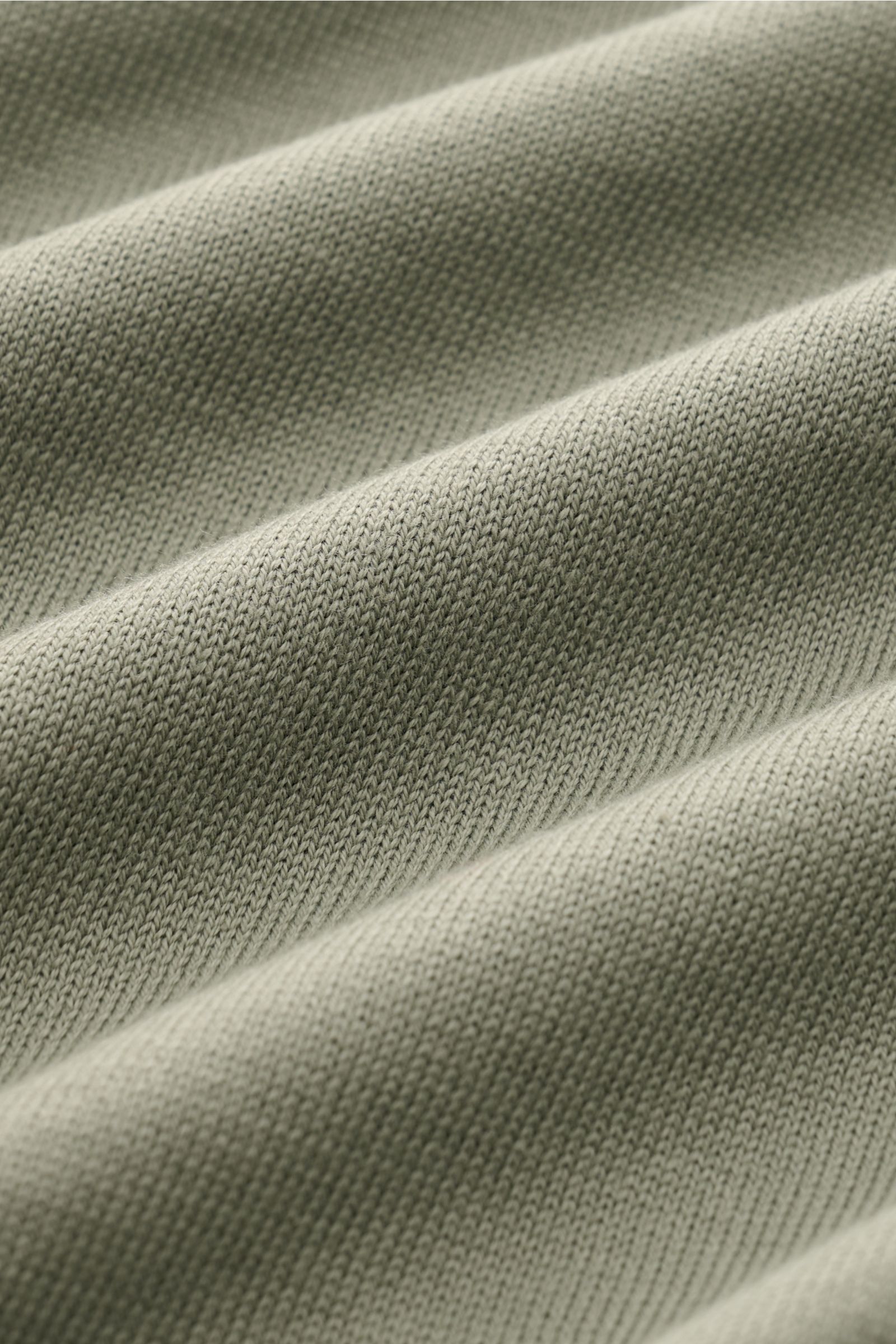 Nahaufnahme des feinen Strickbildes des Malo Kurzarmpullover grün aus reiner Baumwolle mit weichem Griff, Rundhalsausschnitt und Rippbündchen.