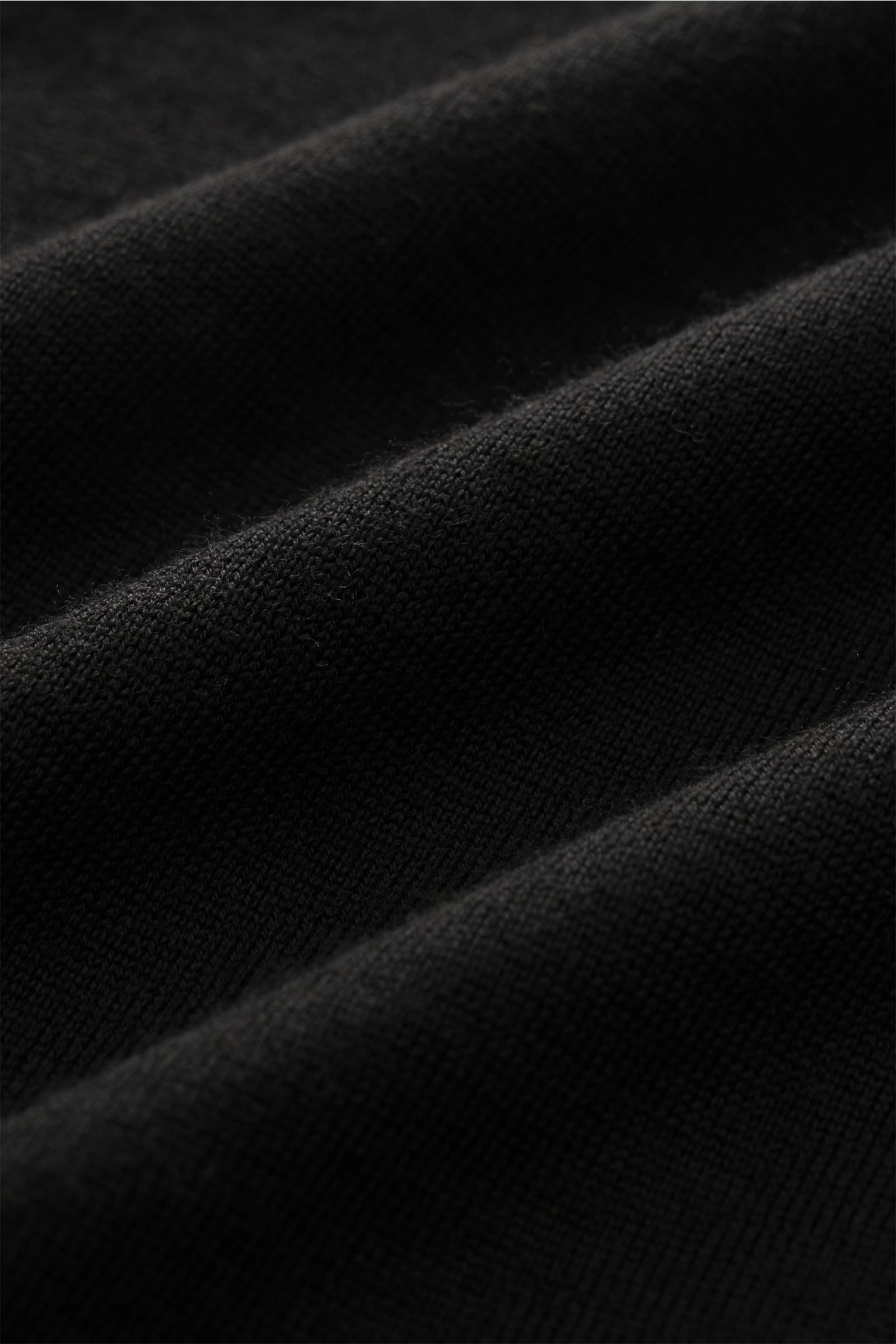 Fioroni Rundhalspullover schwarz in Nahaufnahme, feines Strickbild, reine Schurwolle, sehr weicher Griff, Slim Fit, Rundhalsausschnitt, flexible Rippbündchen, italienische Strickkunst.