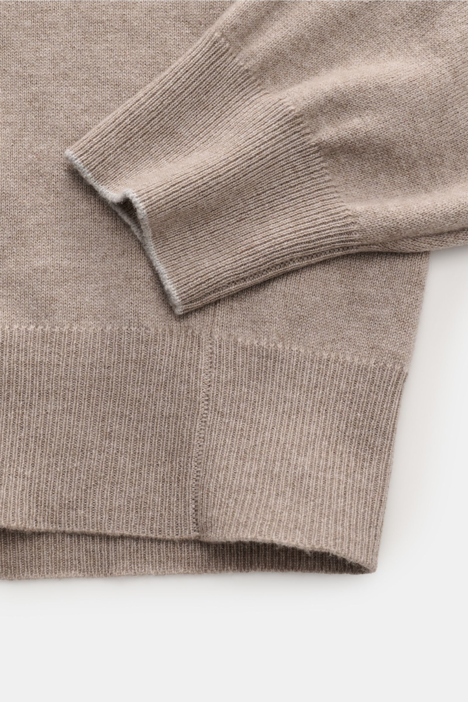 Brunello Cucinelli Cashmere Rollkragenpullover taupe meliert shown in close-up from above, highlighting soft ribbed cuffs and hem. Als vielseitiges Essential bietet dieser luxuriöse Cashmerepullover mit hohem, anliegendem Rollkragen von BRUNELLO CUCINELLI