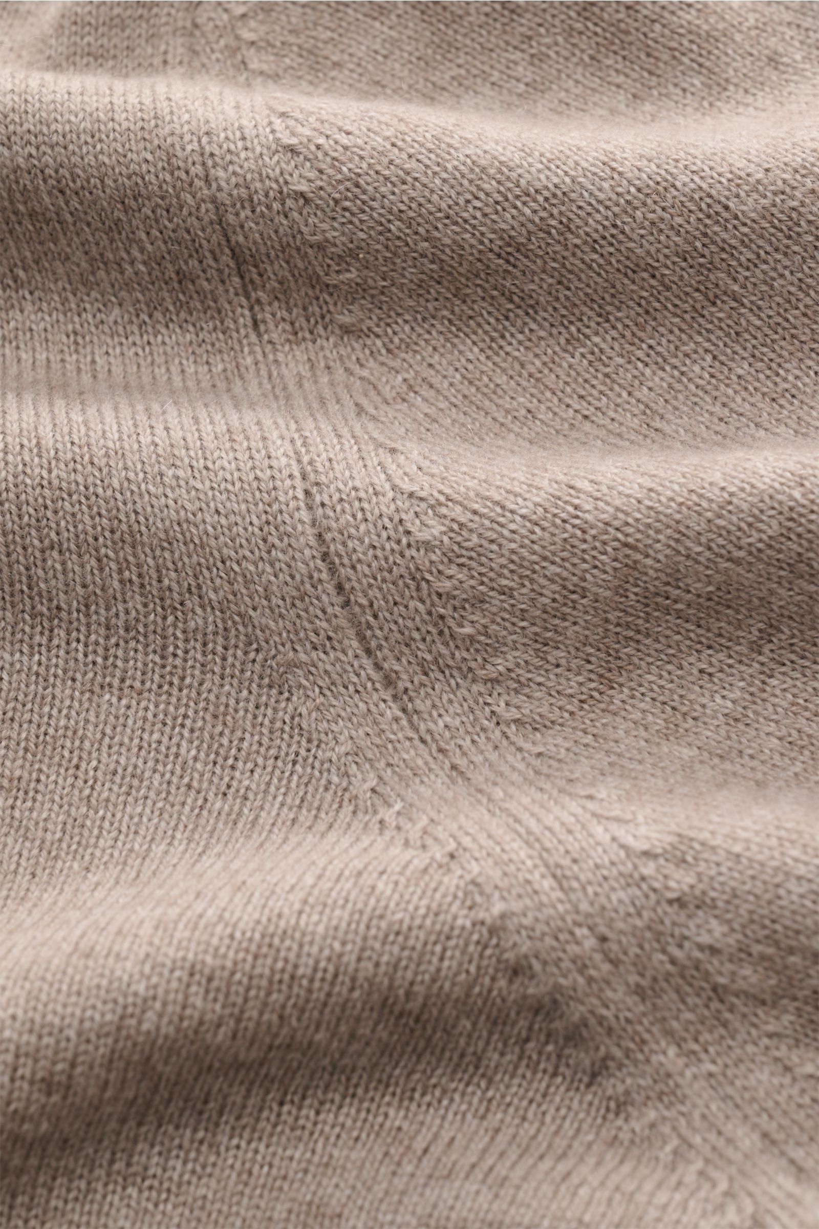 Close-up view of the taupe meliert knitted fabric of the Brunello Cucinelli Cashmere Rollkragenpullover, showing fine stitch detail and soft texture. Als vielseitiges Essential bietet dieser luxuriöse Cashmerepullover mit hohem, anliegendem Rollkragen von