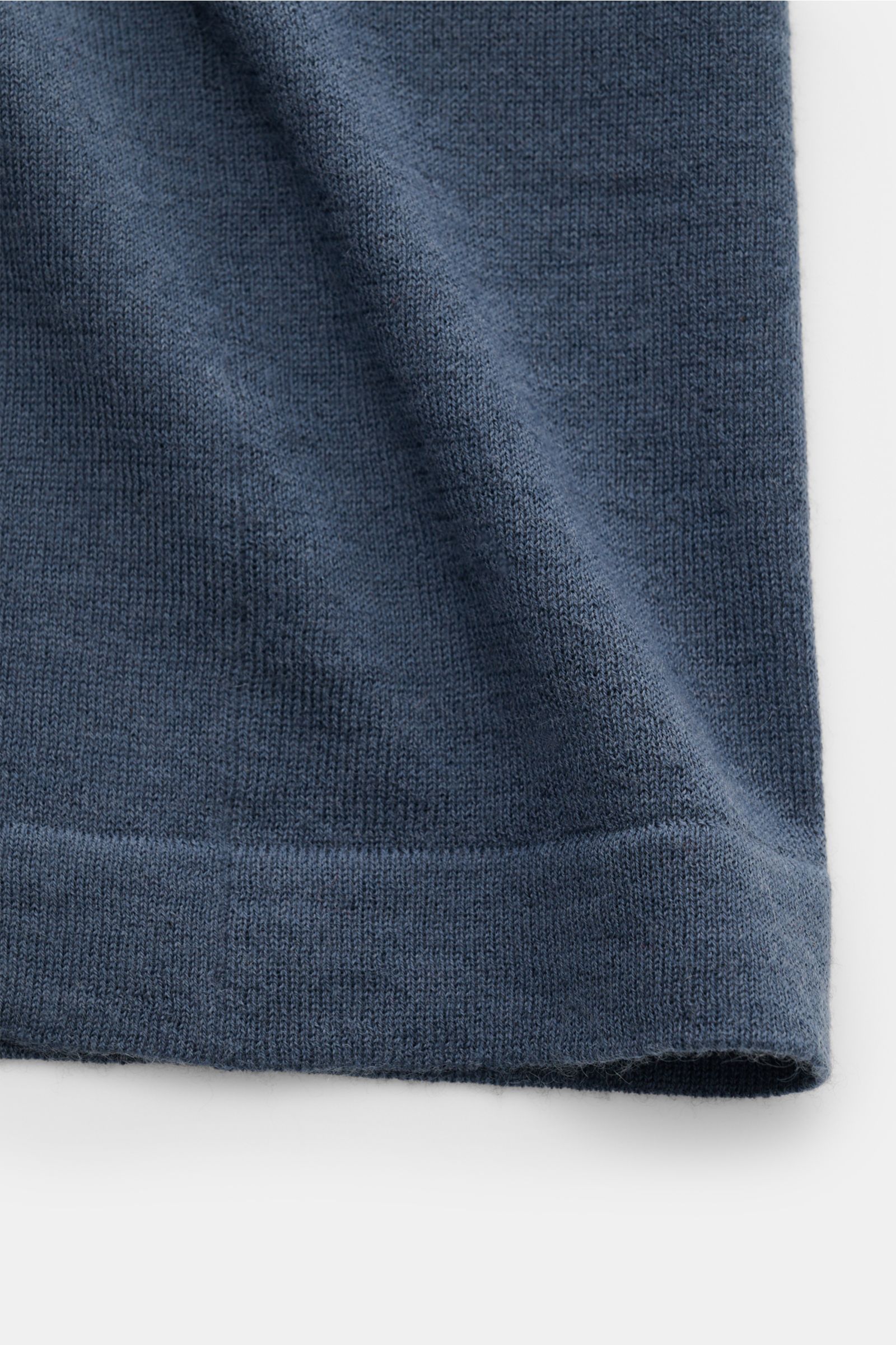 Close-up of the hem and fabric texture of the Lisa Yang Cashmere Strickhemd 'Kieran' graublau, showing its very fine knit in soft grey-blue cashmere from a front-side perspective.

Zeitlos eleganter Komfort: Das vielseitige Strickhemd von LISA YANG übe