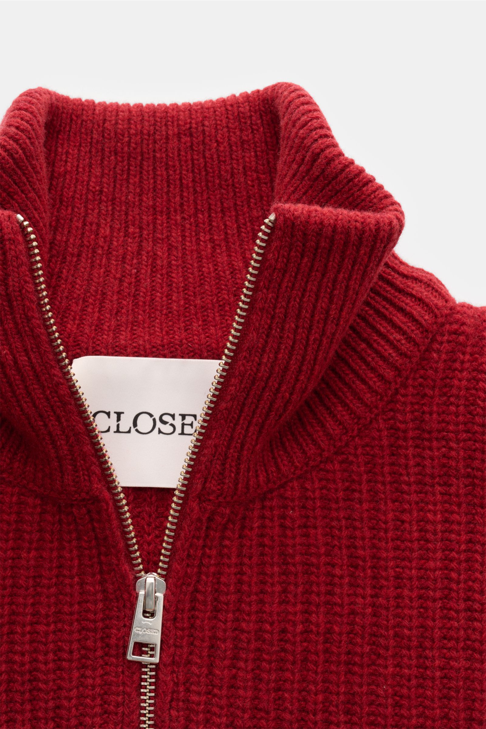 Close-up front view of Closed Troyer rot, a red knit sweater with patentstrick aus reiner Wolle, schwere Qualität, grobes Strickbild, leicht griffige Haptik, Regular Fit, a ribbed collar with zipper, and wide ribbed cuffs.