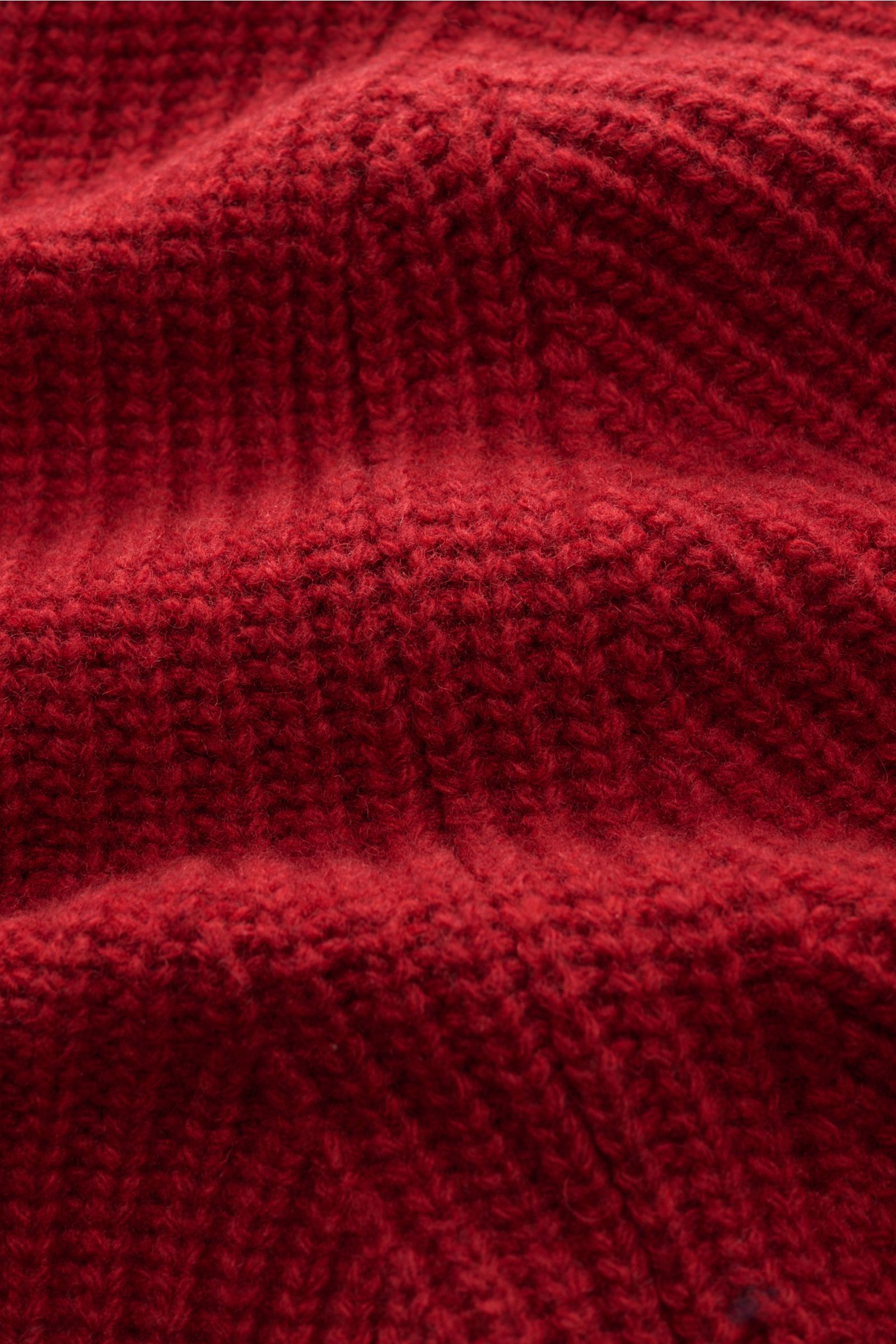 Close-up image of the red wool fabric of the Closed Troyer rot, photographed from a top-down perspective. The image highlights Patentstrick aus reiner Wolle, schwere Qualität, grobes Strickbild, leicht griffige Haptik, Regular Fit, Rippstrickkragen mit Zi
