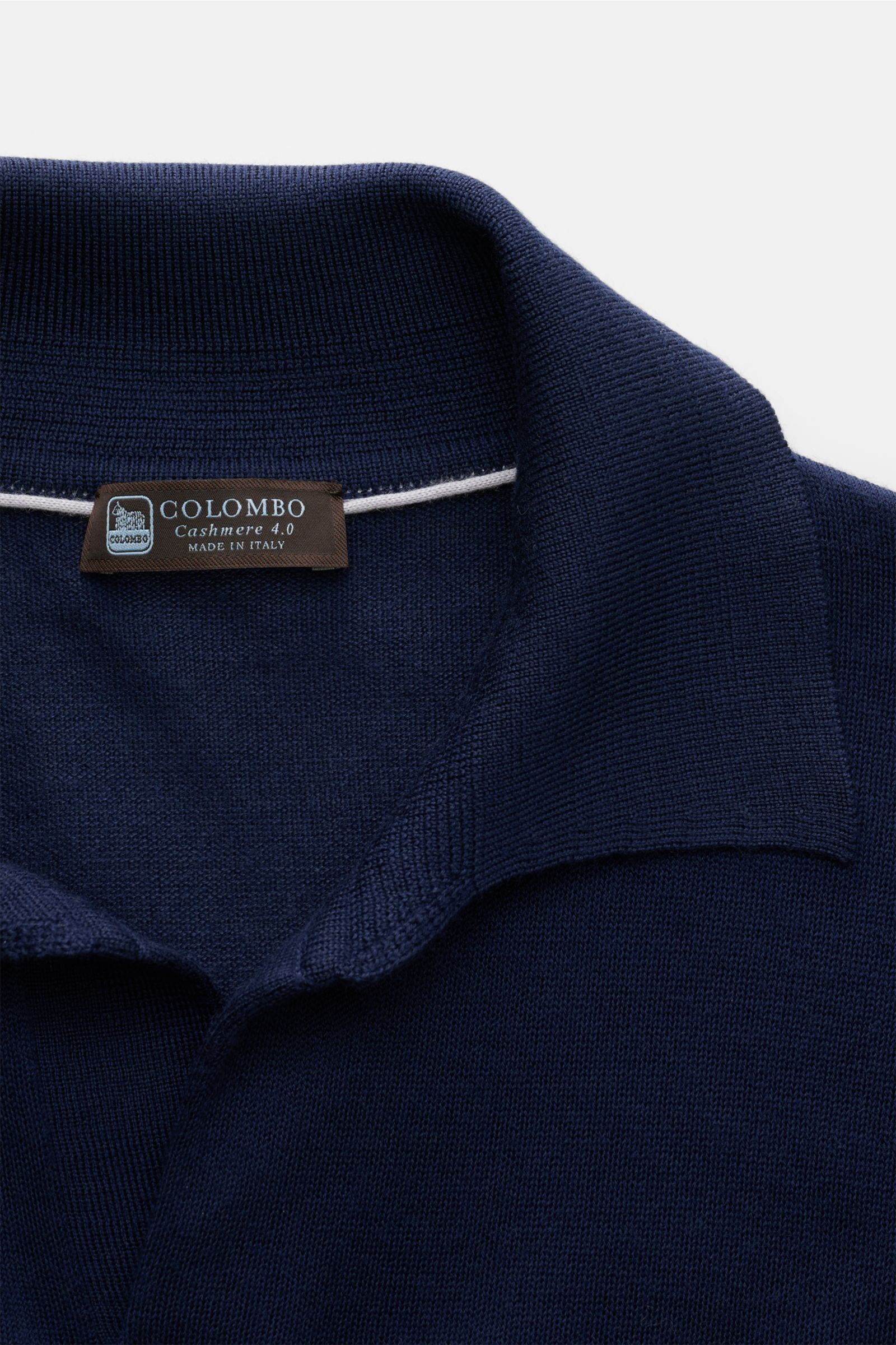 Close-up top-down view of Colombo Cashmere Strickpolo dunkelblau, showcasing fine knit, classic collar, and soft texture.

Description: Edles Winter-Essential von COLOMBO: Das vielseitige Strickpolo aus feinstem Cashmere wird zum luxuriösen Must-Have i