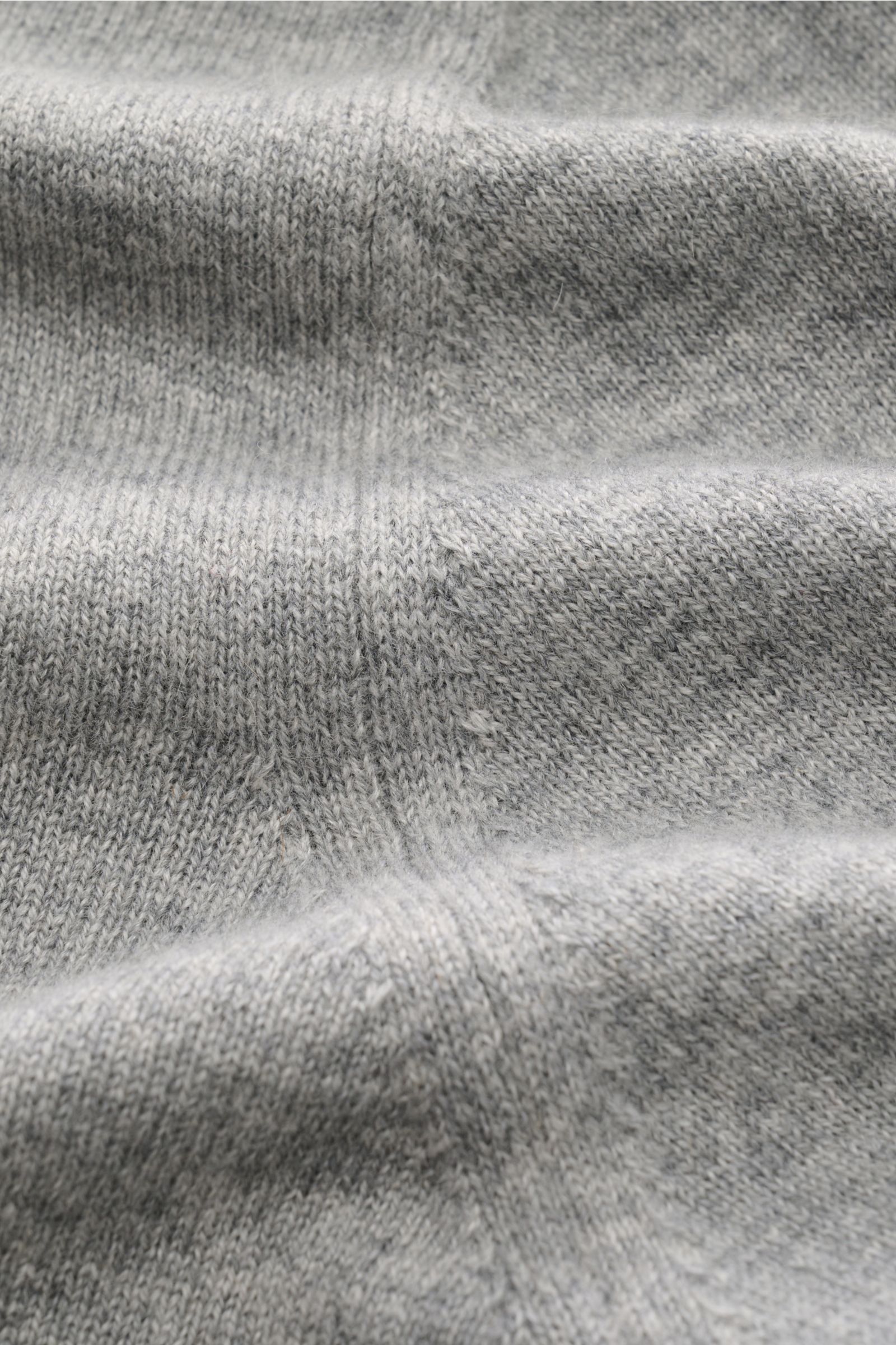 Close-up front view of the fine knit texture of the Cruciani Cashmere Troyer grau meliert in light grey.

Durch die Verwendung feinster, geschmeidiger Cashmere-Garne entsteht bei CRUCIANI ein klassisch leichter Troyer, der Wärme spendet und vielseitig 