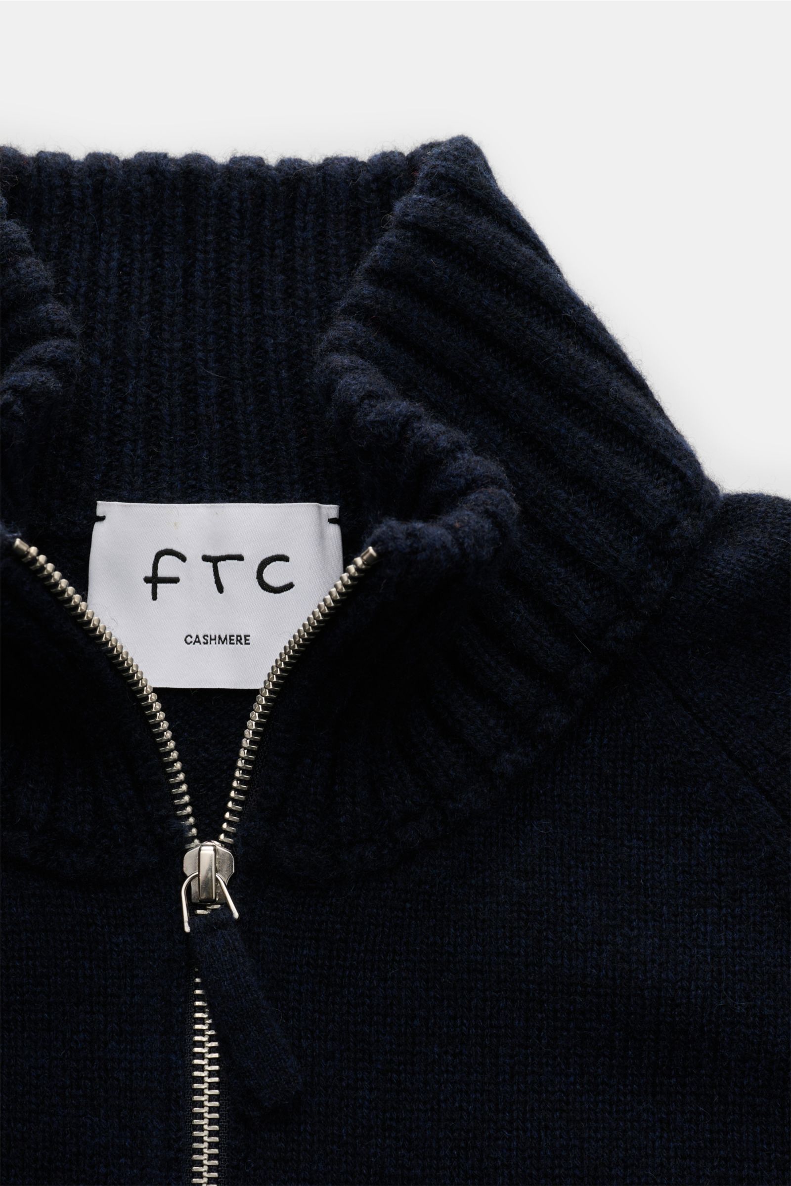Nahaufnahme des FTC Cashmere Troyer navy von oben, mit angesetztem Troyer-Kragen, Zipper, Raglanärmel und Rippbündchen aus Fair-Trade-Cashmere.