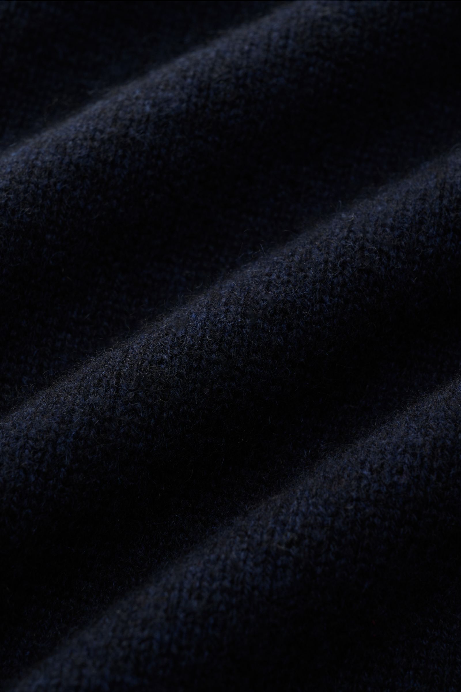 Nahaufnahme des weichen, mittelfeinen Strickbilds vom FTC Cashmere Troyer navy aus Fair-Trade-Cashmere, dargestellt aus Detailperspektive.
