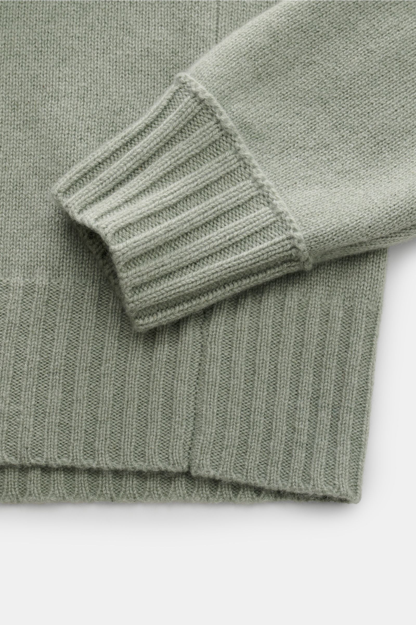 Nahaufnahme des FTC Cashmere Troyer graugrün von FTC mit mittelfeinem Strickbild, Raglanärmel, breit geripptem Rippbündchen und hochwertigem Fair-Trade-Cashmere.