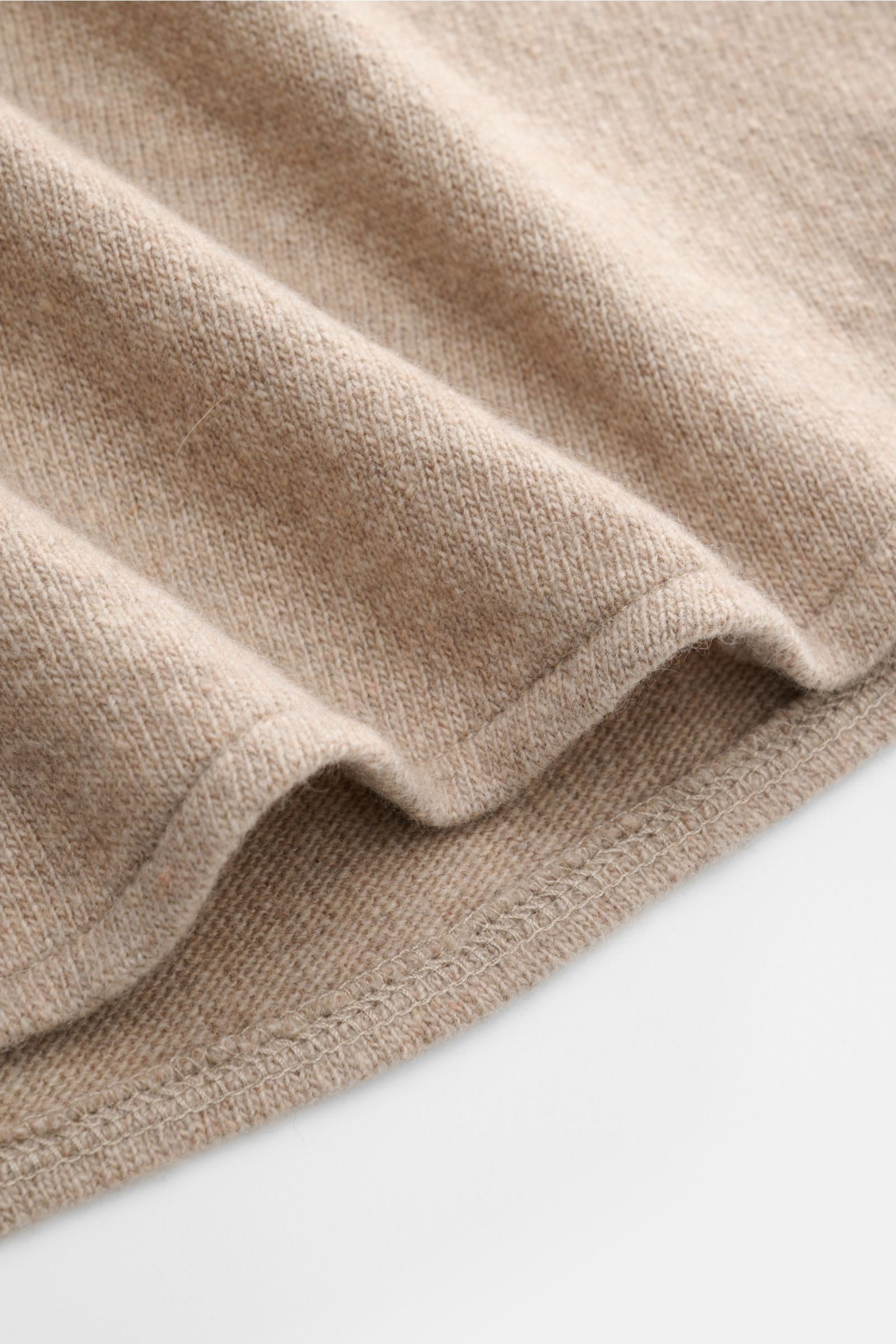 Detailaufnahme des gerundeten Saumverlaufs des B.F. Knitwear Cashmere Strickhemd Kent-Kragen beige aus reinem, feinem und weichem Strick.