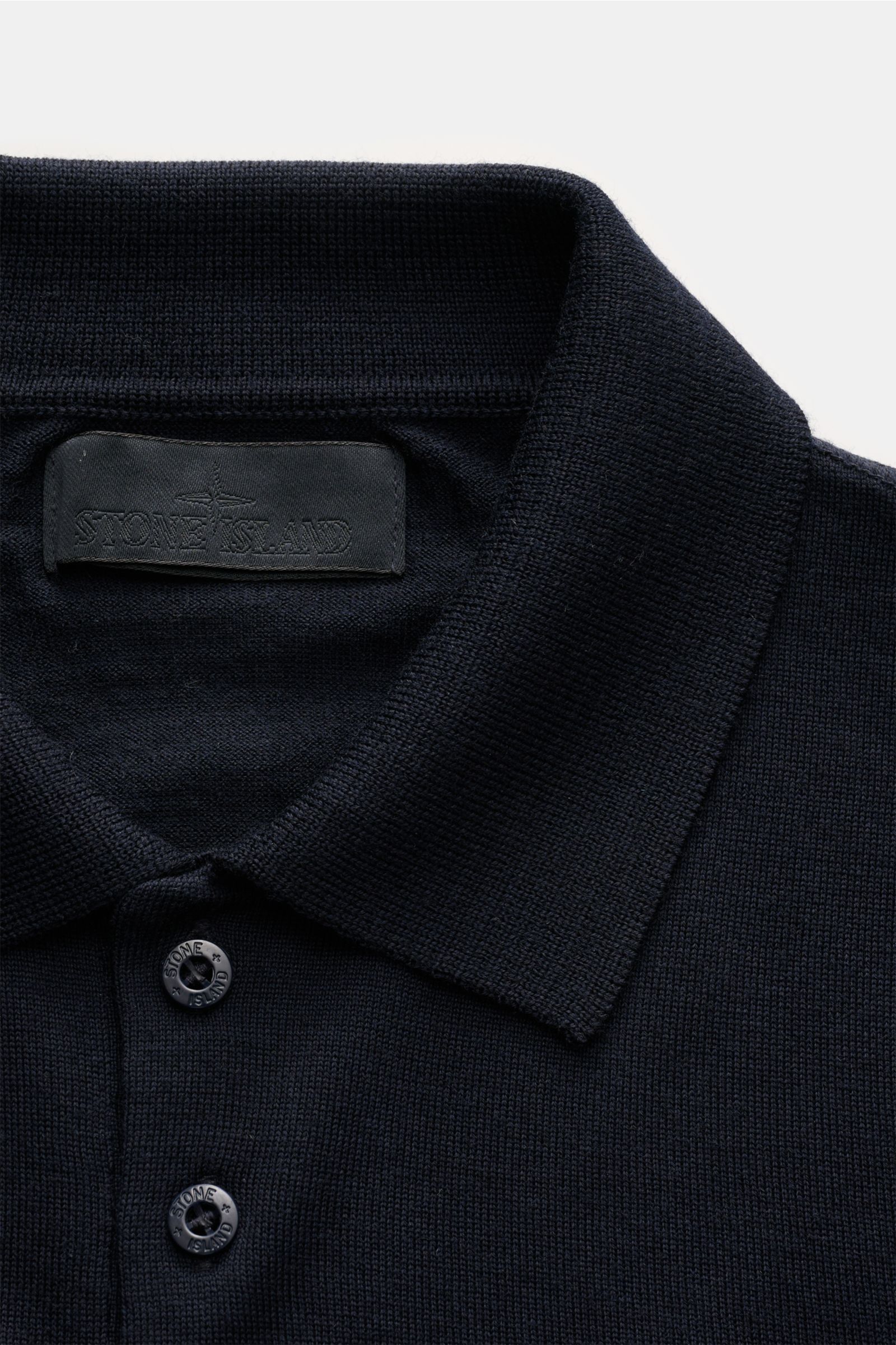 Stone Island Strickpolo 'Ghost Piece' navy, Vorderansicht, aus reiner Schurwolle mit weichem Griff, feinem Strickbild, Polokragen, Drei-Knopf-Leiste, tonalem Kompass-Badge und Rippbündchen.