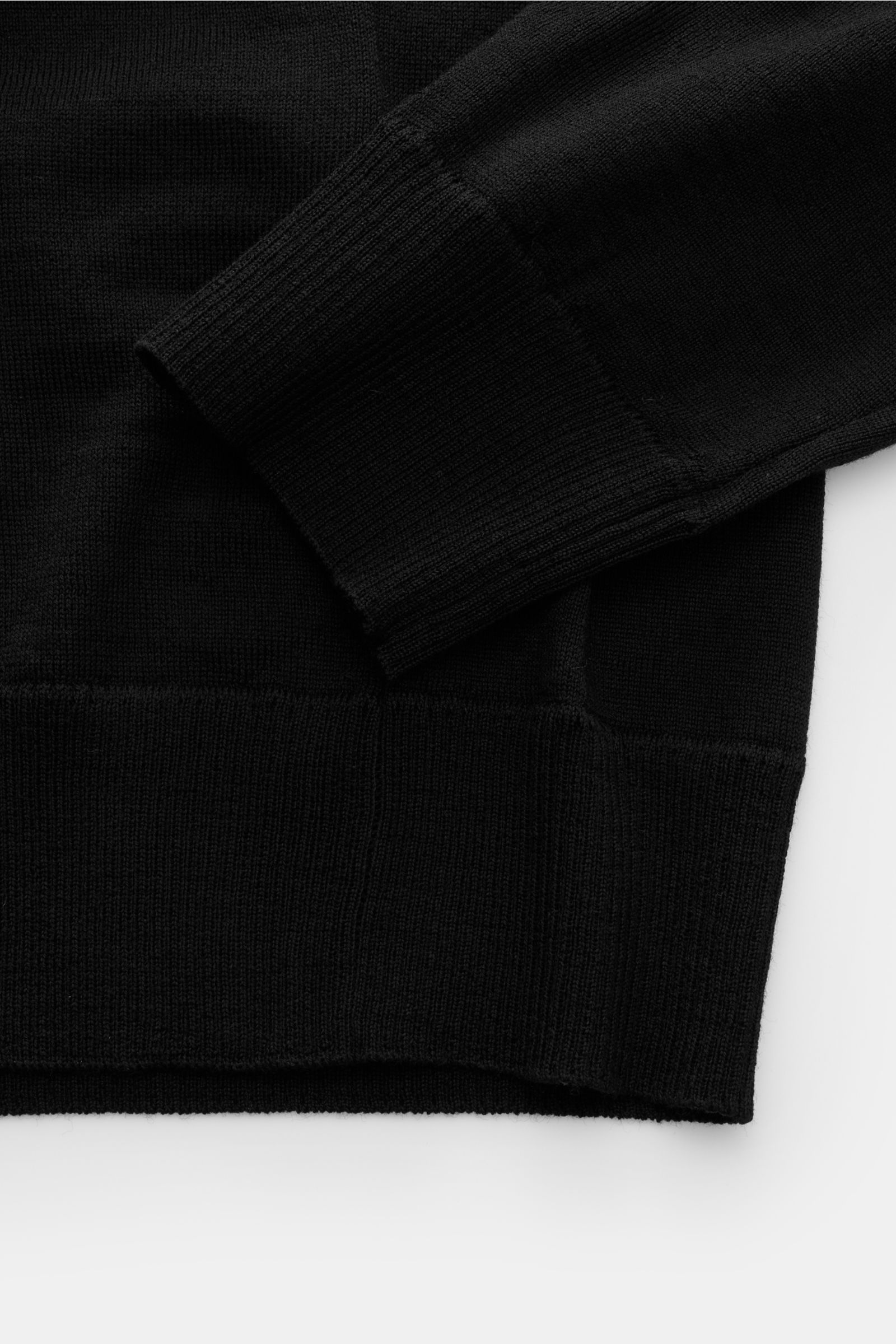 Stone Island Strickpolo 'Ghost Pure Light Wool' schwarz, Detailaufnahme von Ärmel und Saum, weicher Griff, feines Strickbild, Regular Fit, klassischer Umlegekragen, Kompass-Badge am Oberarm, komfortable Rippbündchen.