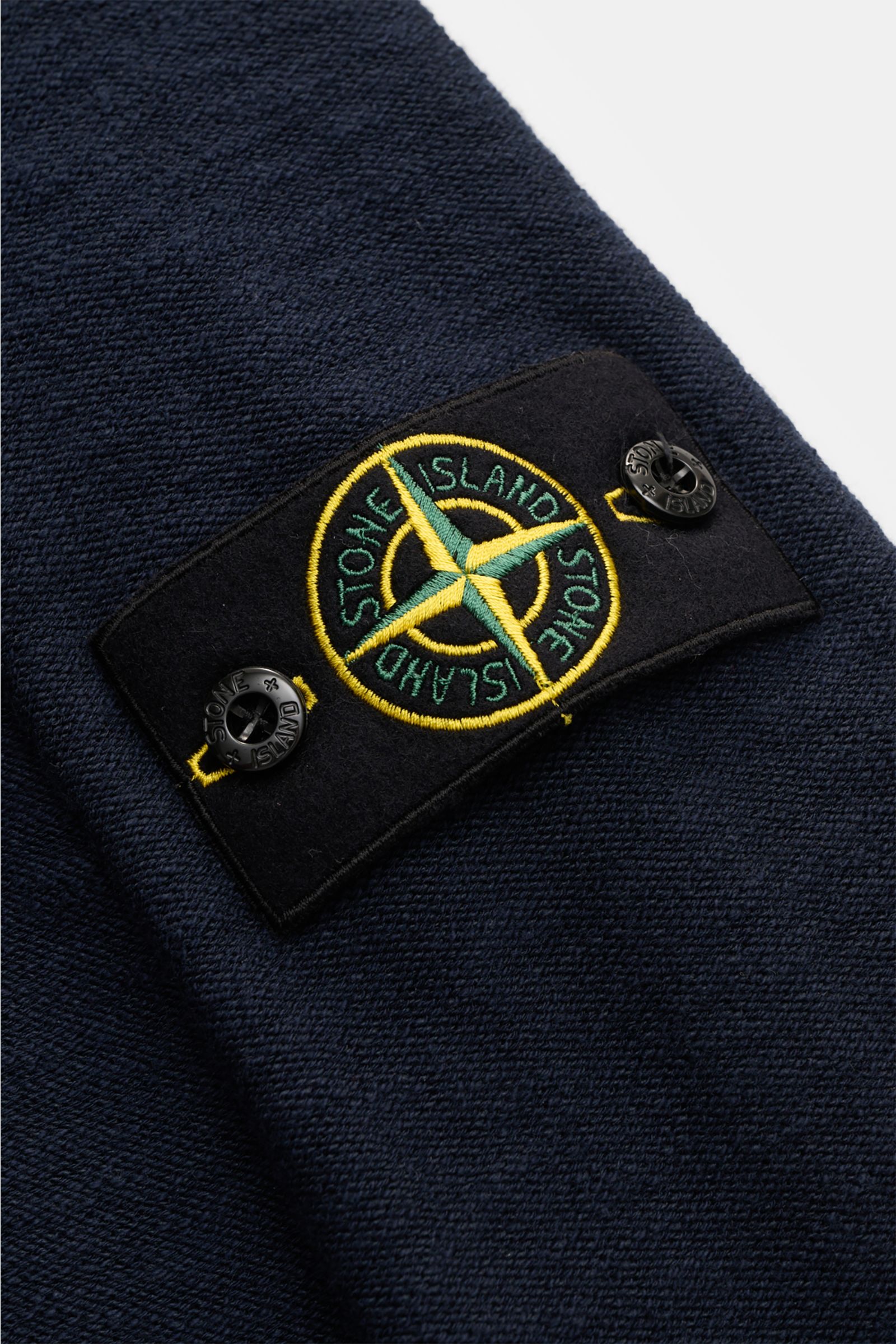 Stone Island Troyer navy Detailaufnahme des markentypischen Kompass-Badges auf linksgestricktem Baumwoll-Microfaser-Strick mit Rippstrickbündchen.