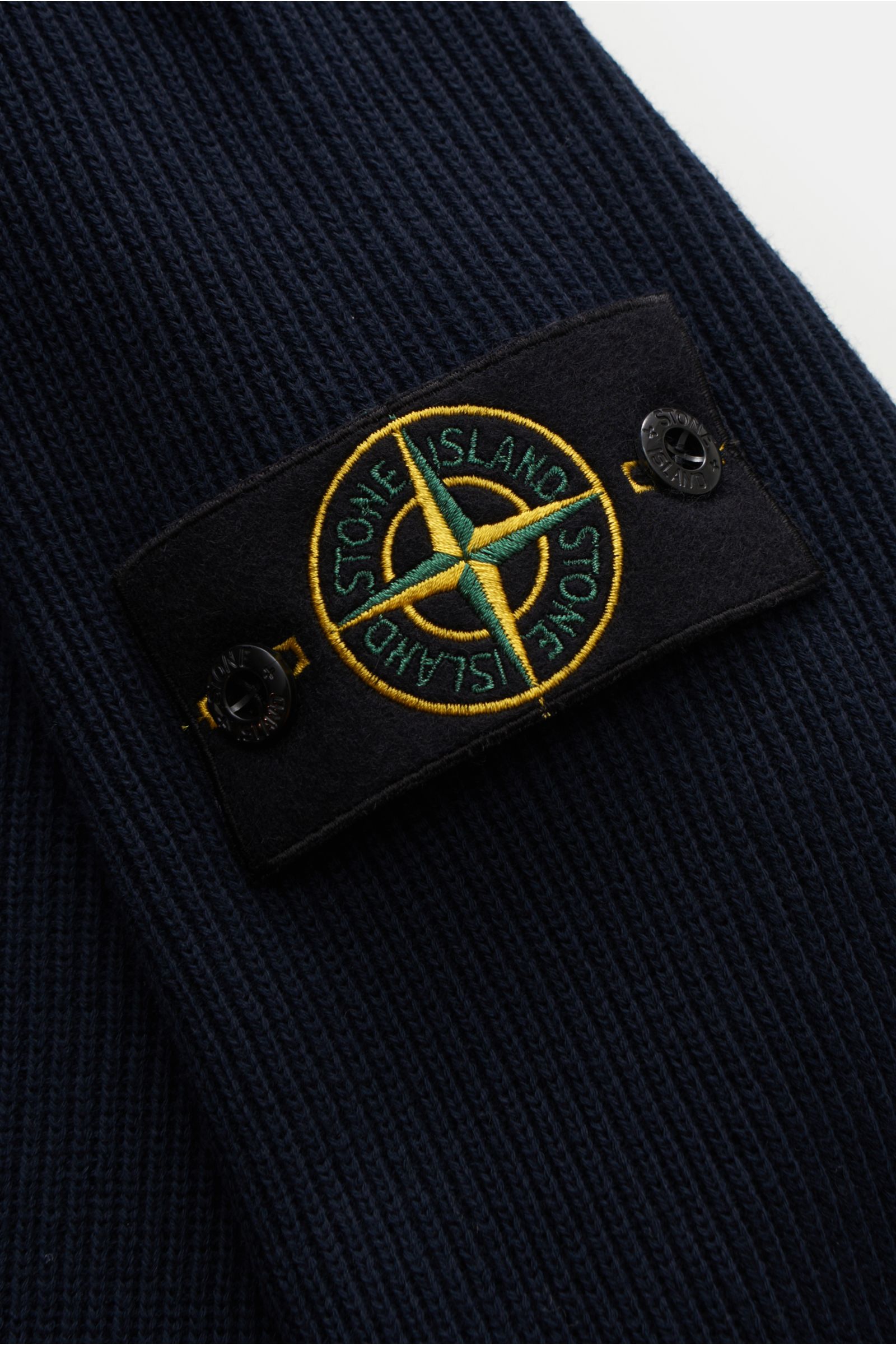 Close-up, angled view of the Stone Island Troyer navy showing the textured cotton knit fabric and the iconic compass badge on the upper arm. Vielseitiger Begleiter in der Übergangszeit: Der Troyer von STONE ISLAND wird mit seinem angenehmen Baumwollstr