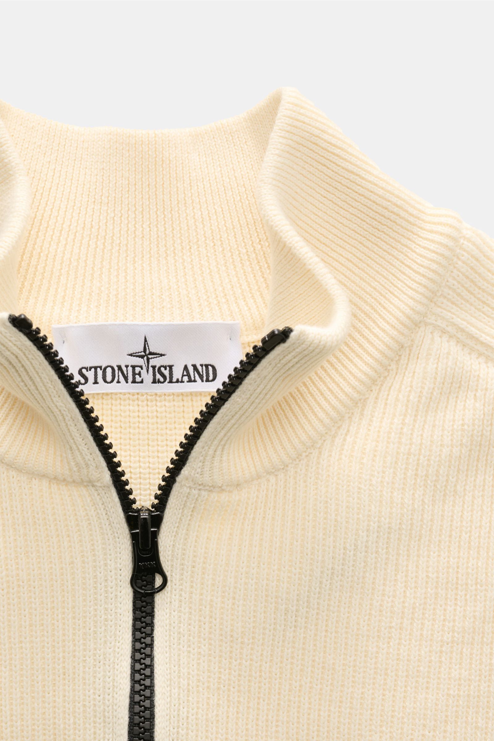 Nahaufnahme des Stone Island Troyer pastellgelb aus Baumwollstrick, mit Rippstrickkragen, halbem Zipper und sichtbarem Markenlabel.