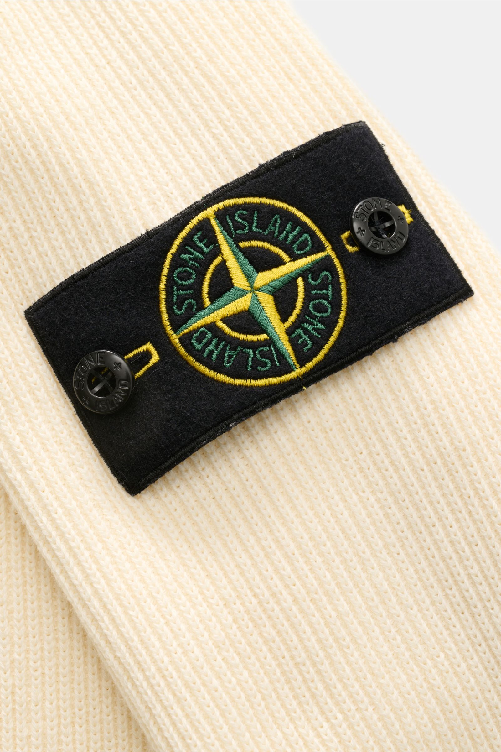 Stone Island Troyer pastellgelb in Nahaufnahme von oben, reine Baumwolle mit Kompass-Badge, Raglanärmel und Rippstrickbündchen.