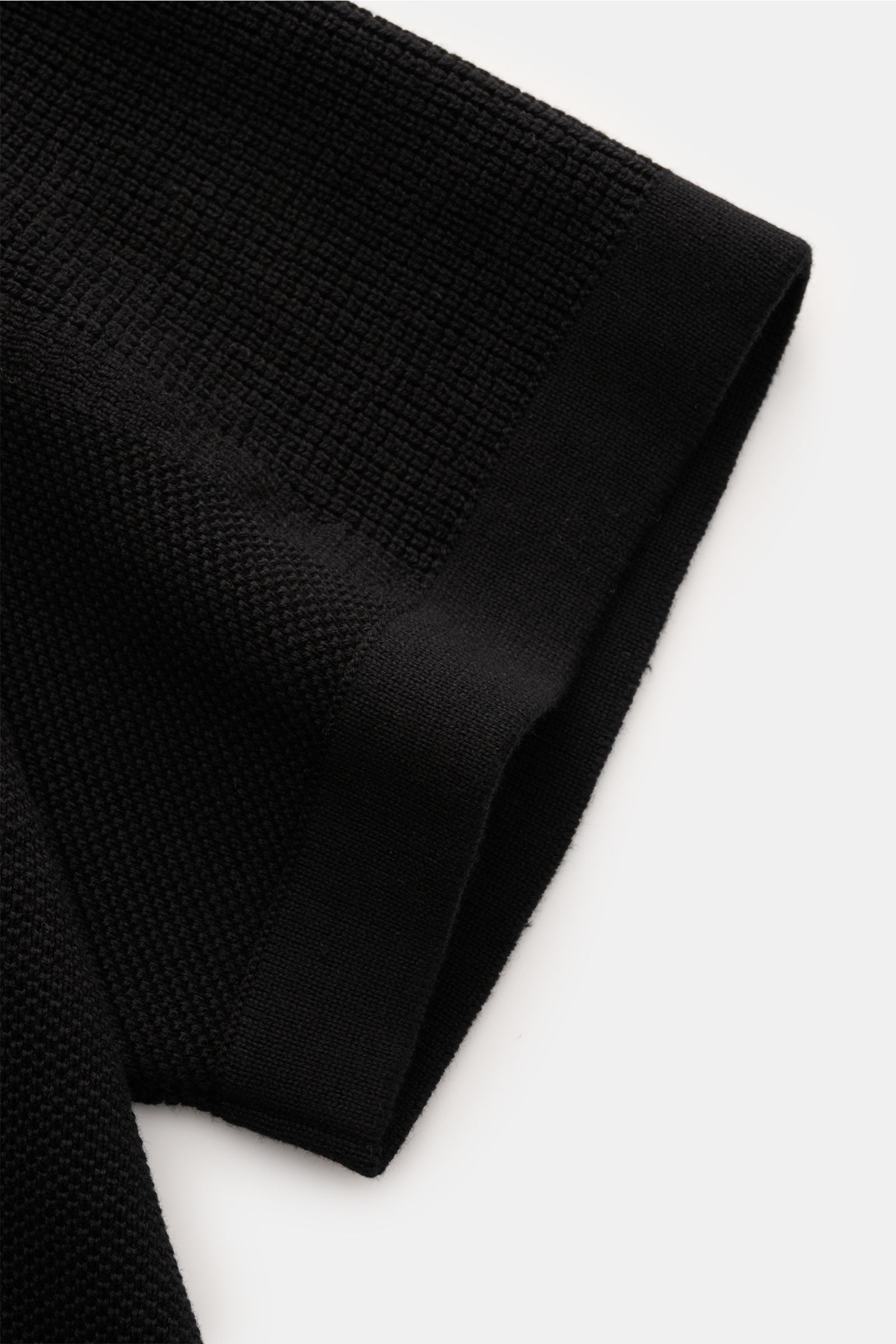 Stone Island Kurzarm-Strickpolo schwarz, Nahaufnahme des Ärmels mit feinem Piqué-Mix, Regular Fit, Polokragen, Weblabel, Saumschlitzen und doppelt gearbeiteten Saumabschlüssen.