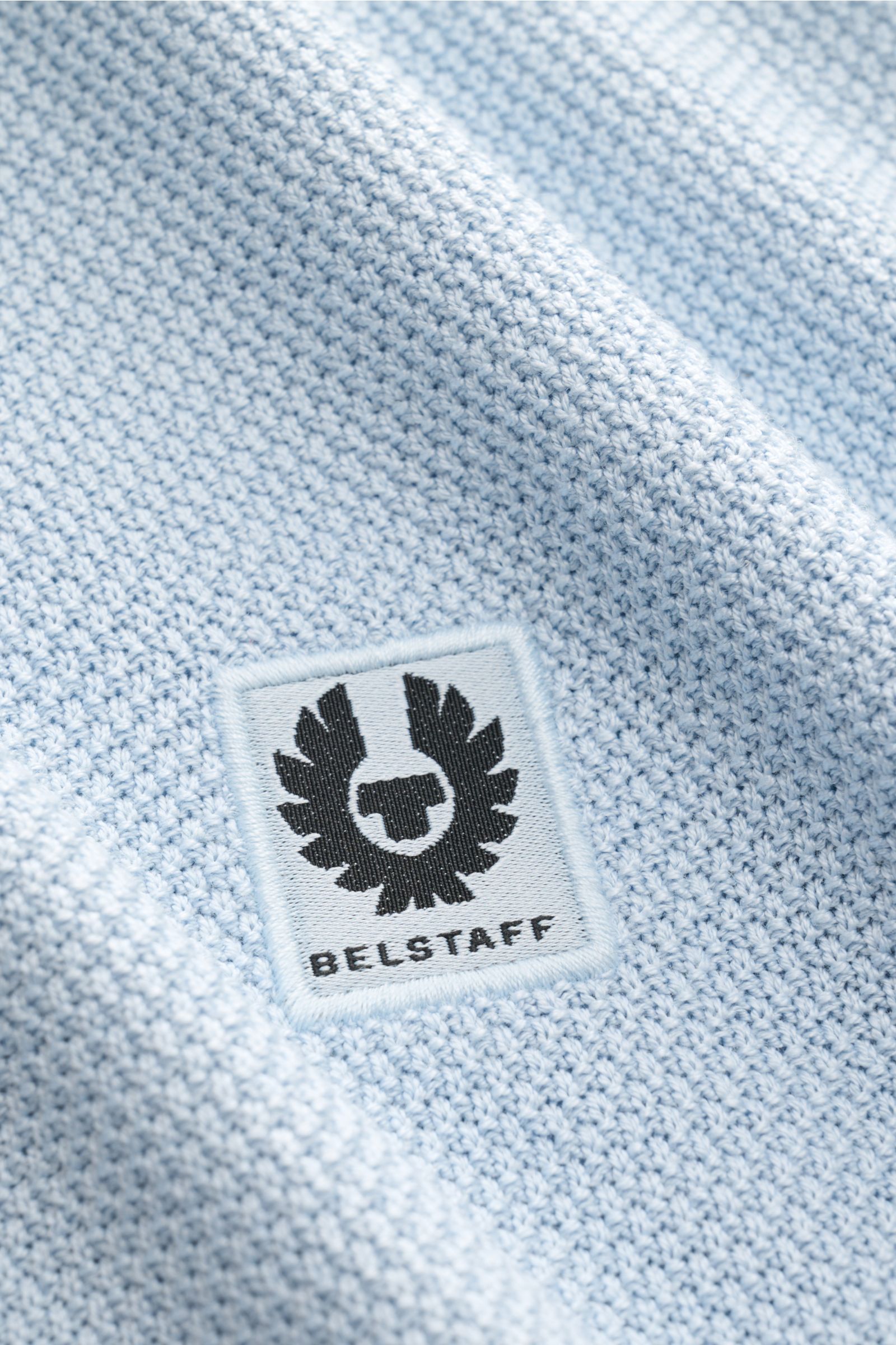 Nahaufnahme des Weblabels auf dem Oberarm des Belstaff Kurzarm-Strickpolo 'Coast' hellblau in feinem Strukturstrick aus Seide und Baumwolle.