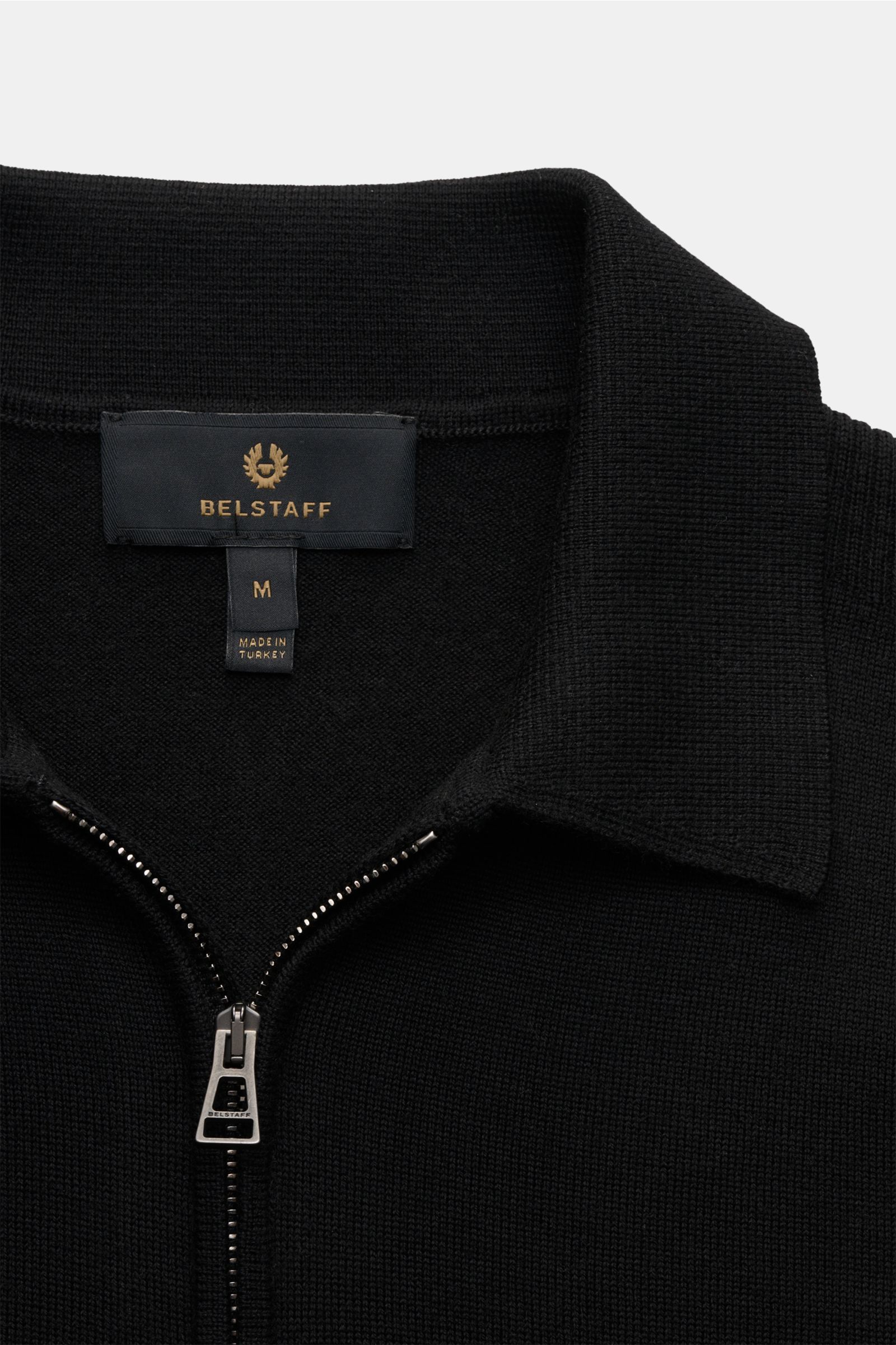 Belstaff Strickpolo 'Kyle' schwarz aus feiner Wolle, Slim Fit, Polokragen mit Reißverschluss, Weblabel am Oberarm, weicher Griff, Rippbündchen, Detailfoto von oben.