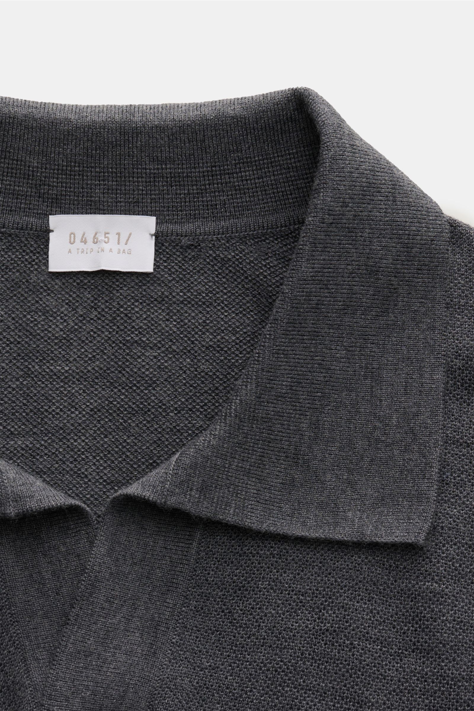Close-up front view of the 04651/ A trip in a bag Knit polo 'Johnny' dark grey showing fine knit texture and narrow collar.

Stylish comfort: This knit polo by 04651/ A TRIP IN A BAG in comfortable pure wool material is a versatile favourite for the au