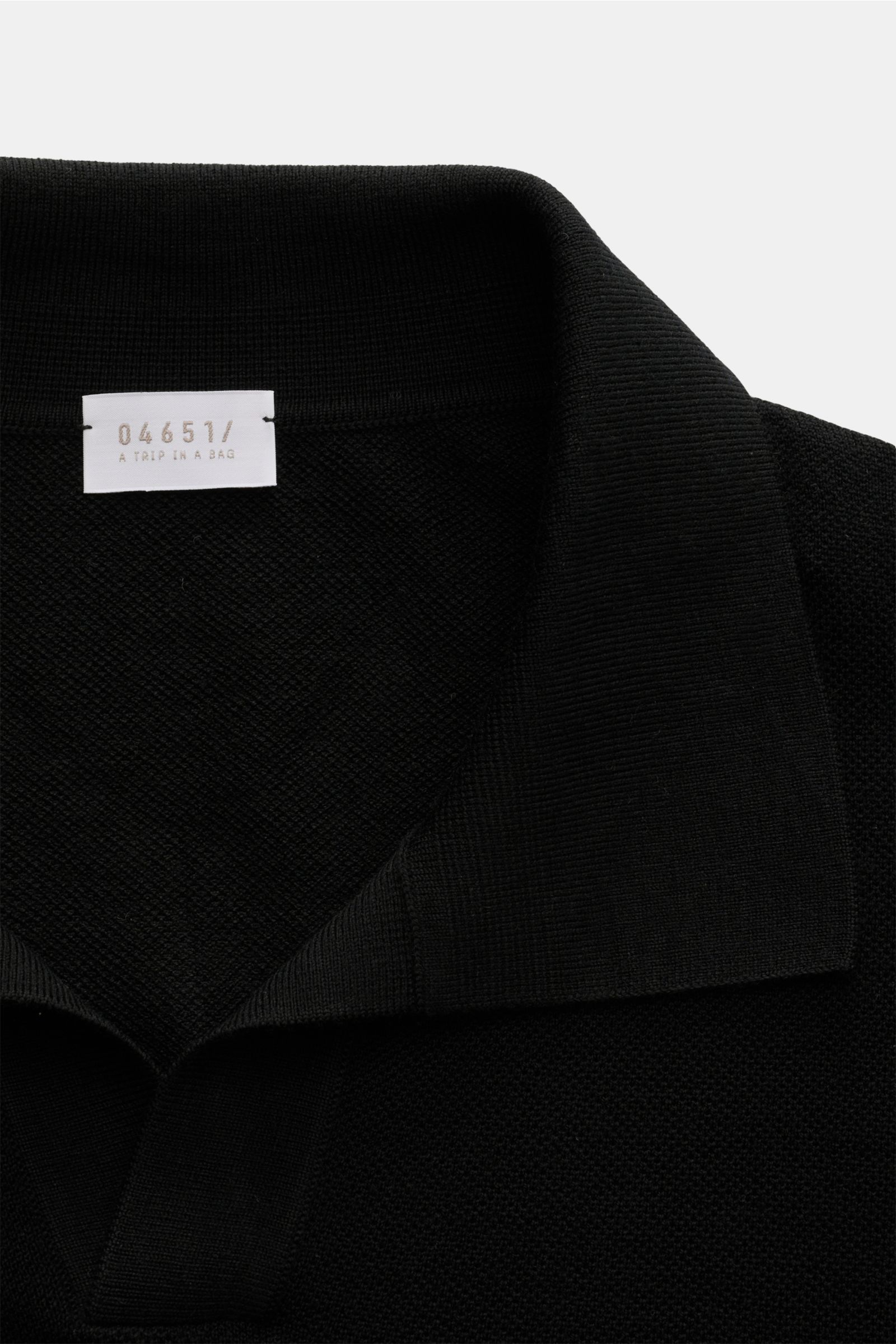 Close-up front view of the narrow collar and label of the 04651/ A trip in a bag Knit polo 'Johnny' black in fine knit pure wool.

Description:  
Stylish comfort: This knit polo by 04651/ A TRIP IN A BAG in comfortable pure wool material is a versatile