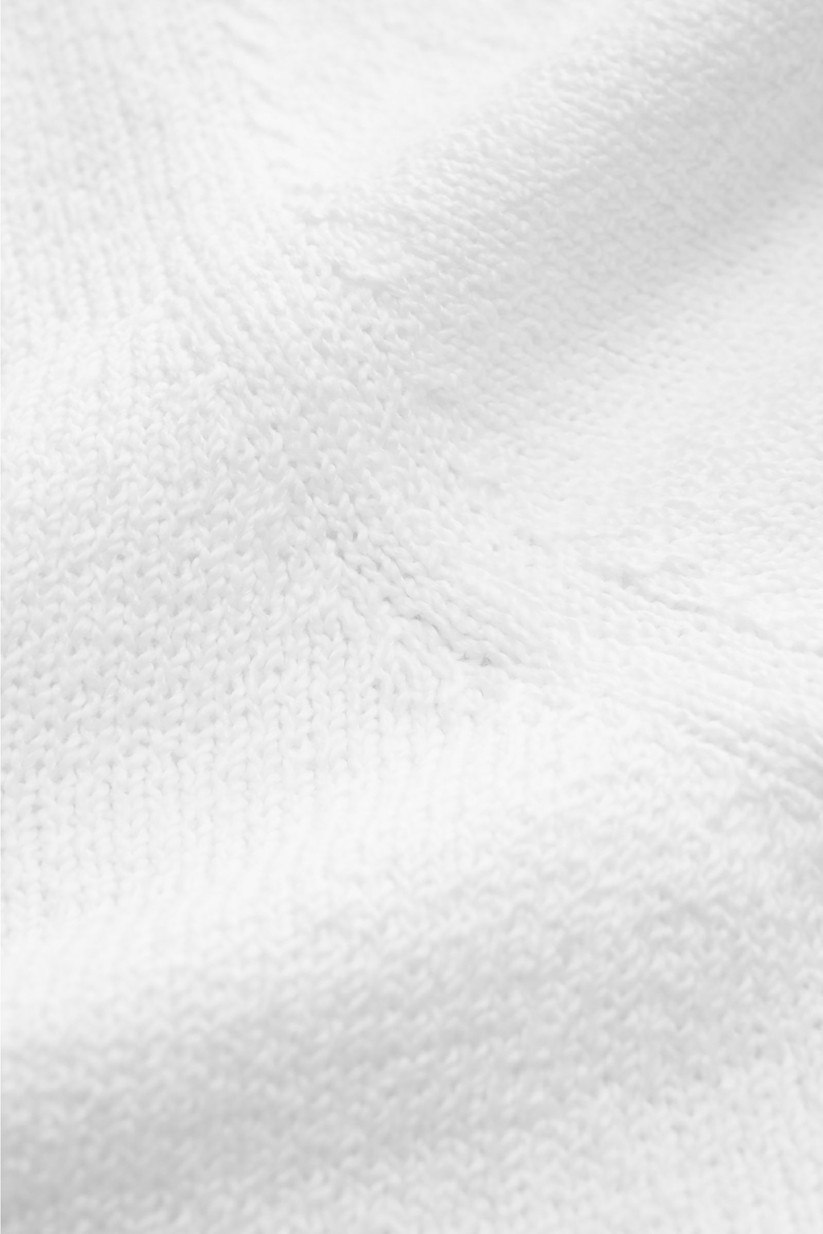 Nahaufnahme des weißen Fioroni V-Neck Pullovers aus reiner Baumwolle mit mittelfeinem Strickbild und halbem Stehkragen, weich und slim fit.