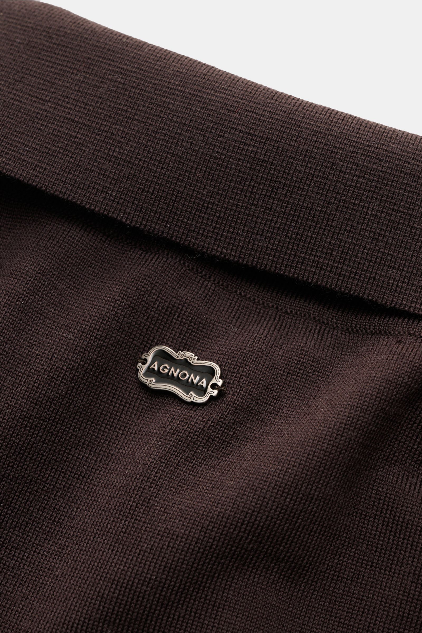 Agnona Strickpolo dunkelbraun aus reiner Wolle, Slim Fit, feines Strickbild, hochschließender Kragen mit Metall-Logo, Detailaufnahme von oben.