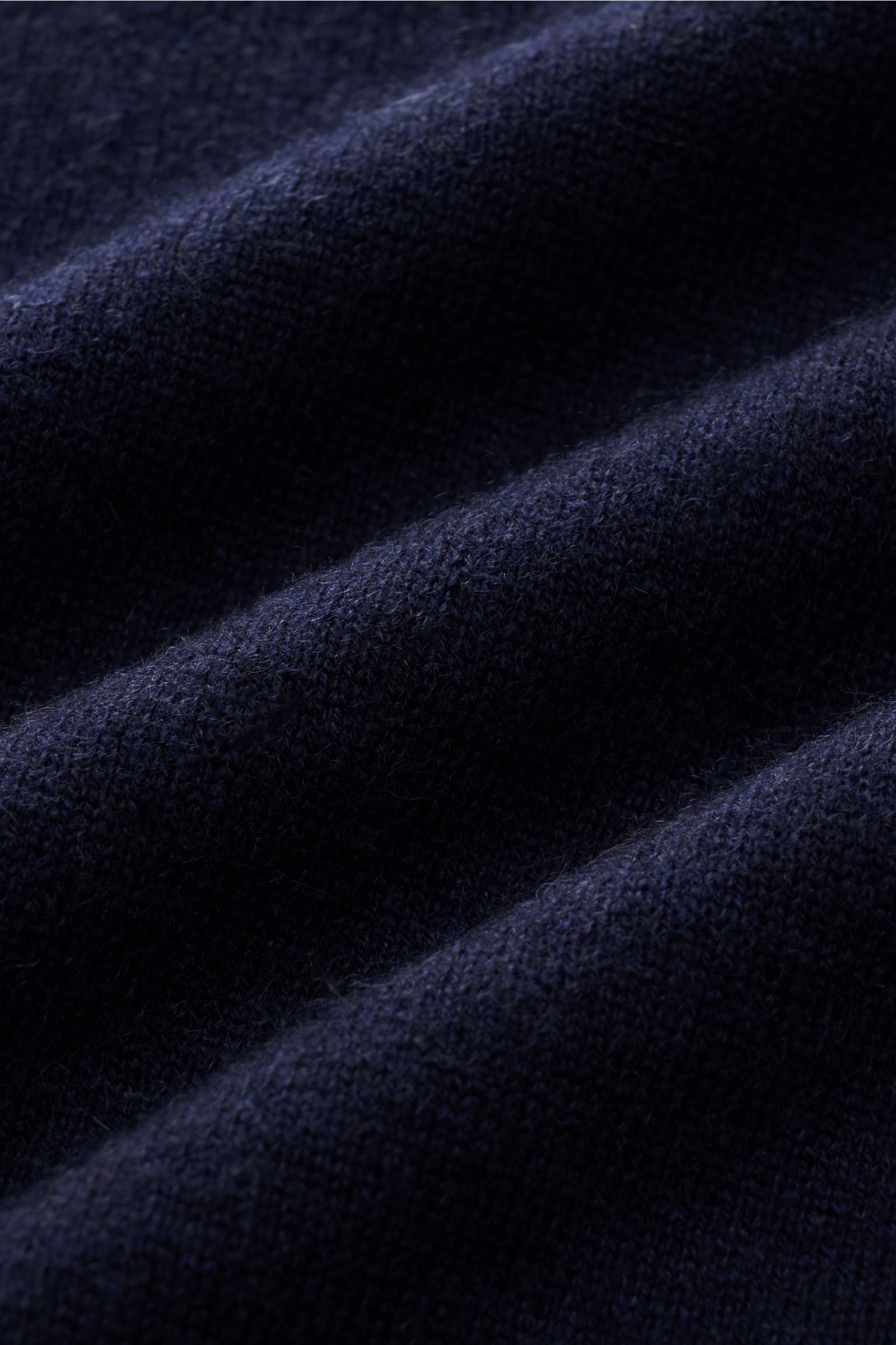 Close-up front angled view of Brunello Cucinelli Cashmere Troyer navy fabric showing fine knit texture, soft grip, and rich navy color, a sportive leisure essential made in Solomeo with pure cashmere, narrow contrast edges, regular fit, Troyer collar with